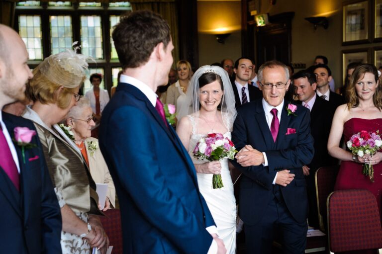 happy smiling bride walking down the aisle with her dad