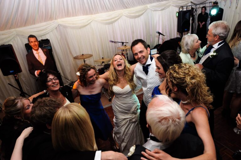 bride and groom with a group of friends dancing