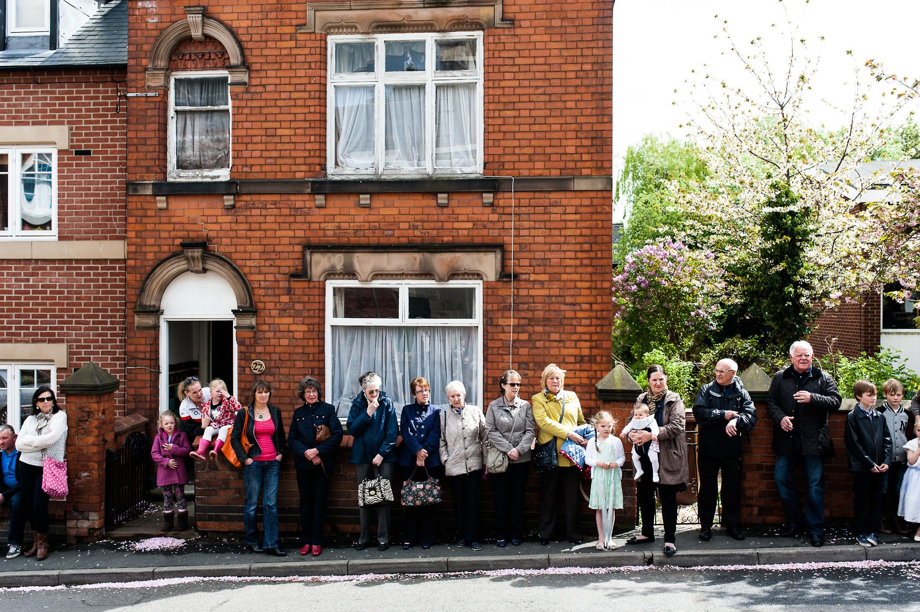 An English Village Wedding in Melbourne Derbyshire villagers line the street as the couple leave the church
