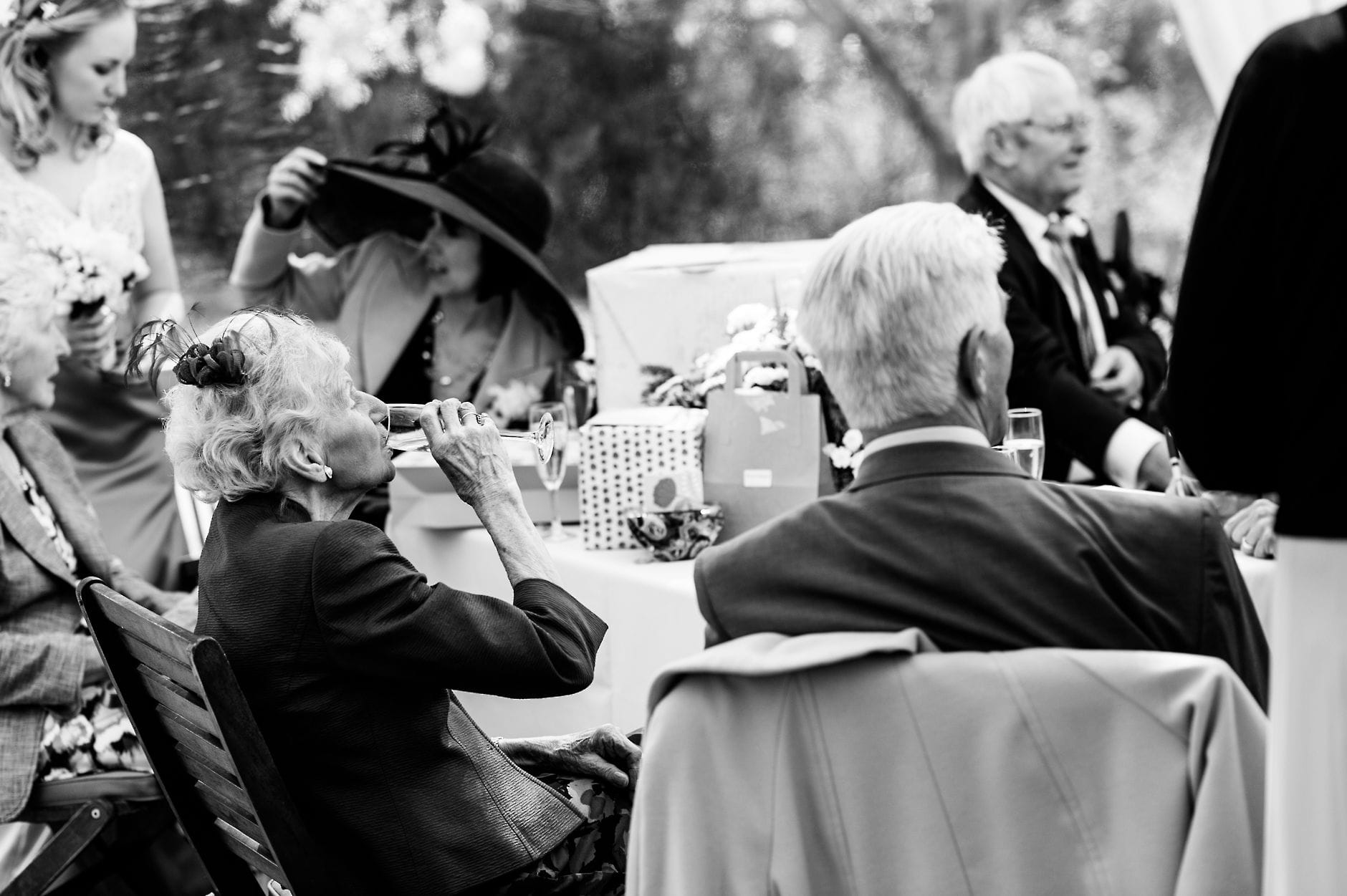 An English Village Wedding in Melbourne Derbyshire elderly lady drinking wine at a wedding