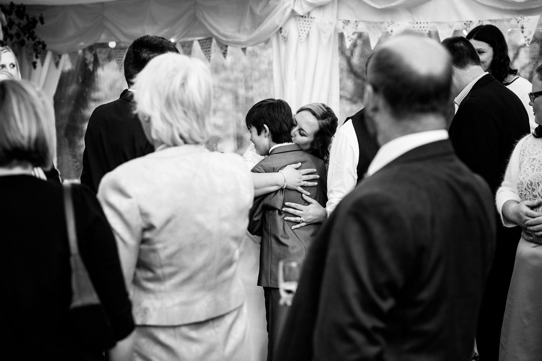 An English Village Wedding in Melbourne Derbyshire bride hugging a young wedding guest