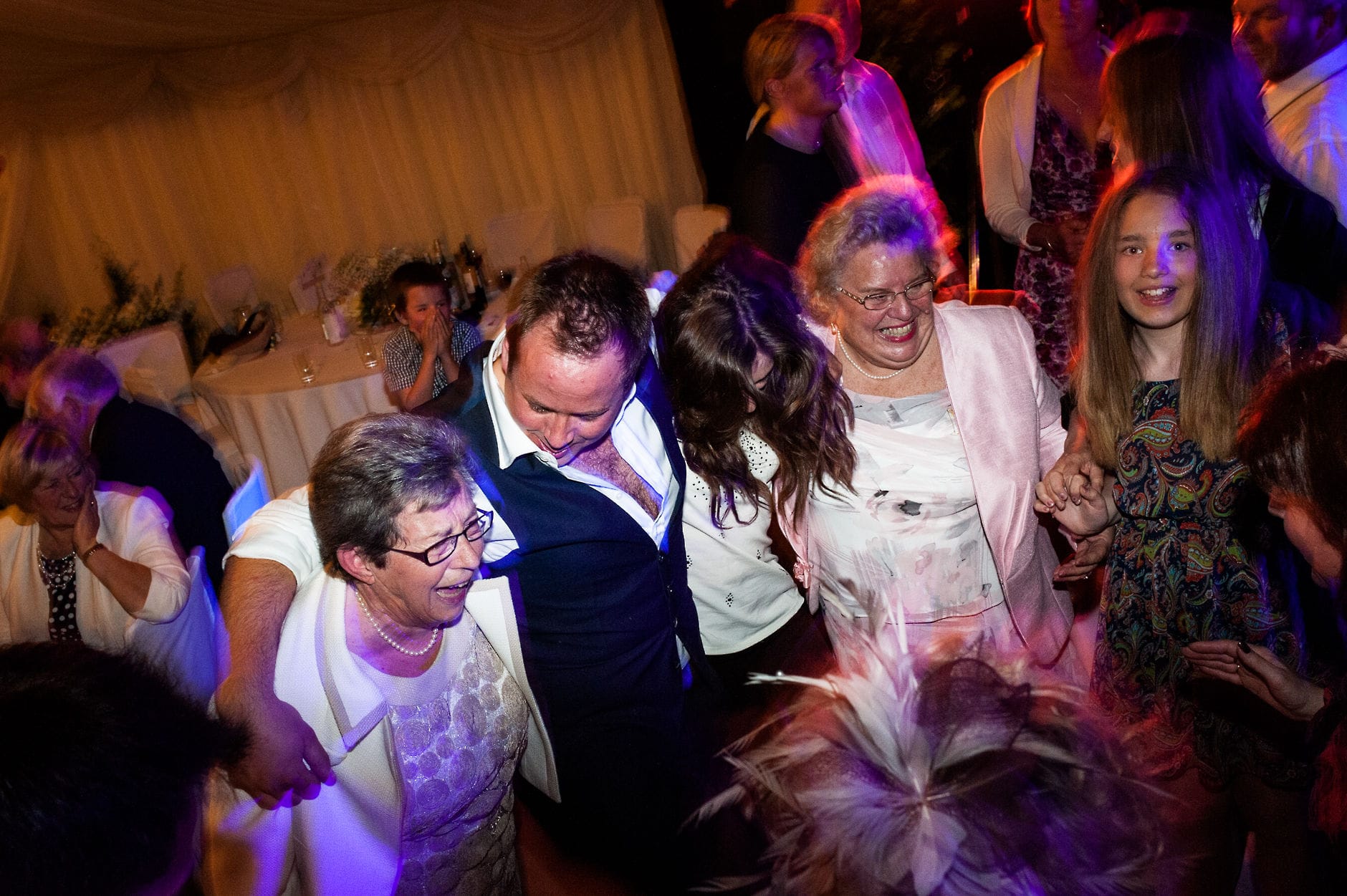 An English Village Wedding in Melbourne Derbyshire groomsman dancing with ladies wedding reception