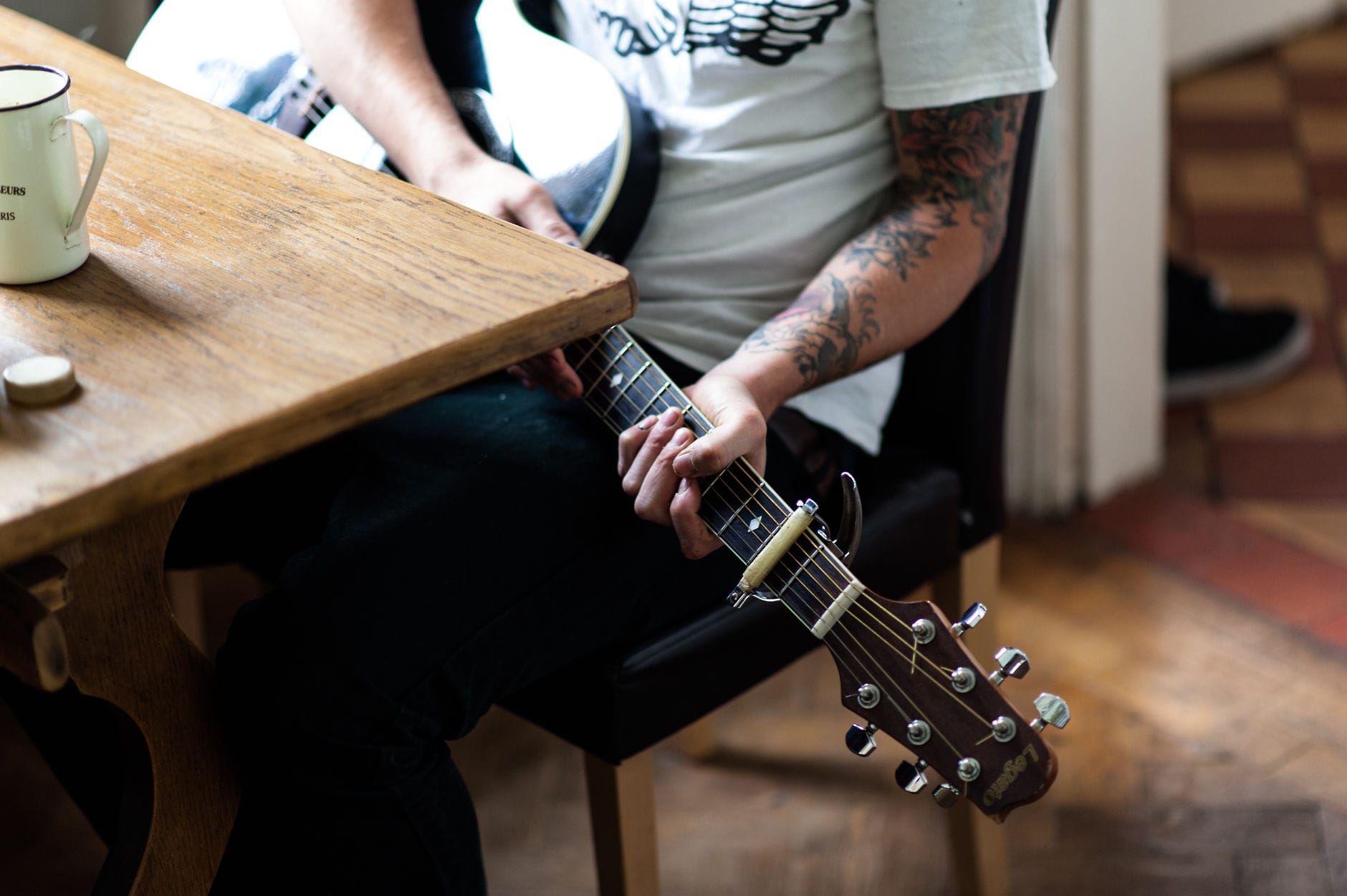tattooed wedding best man playing guitar