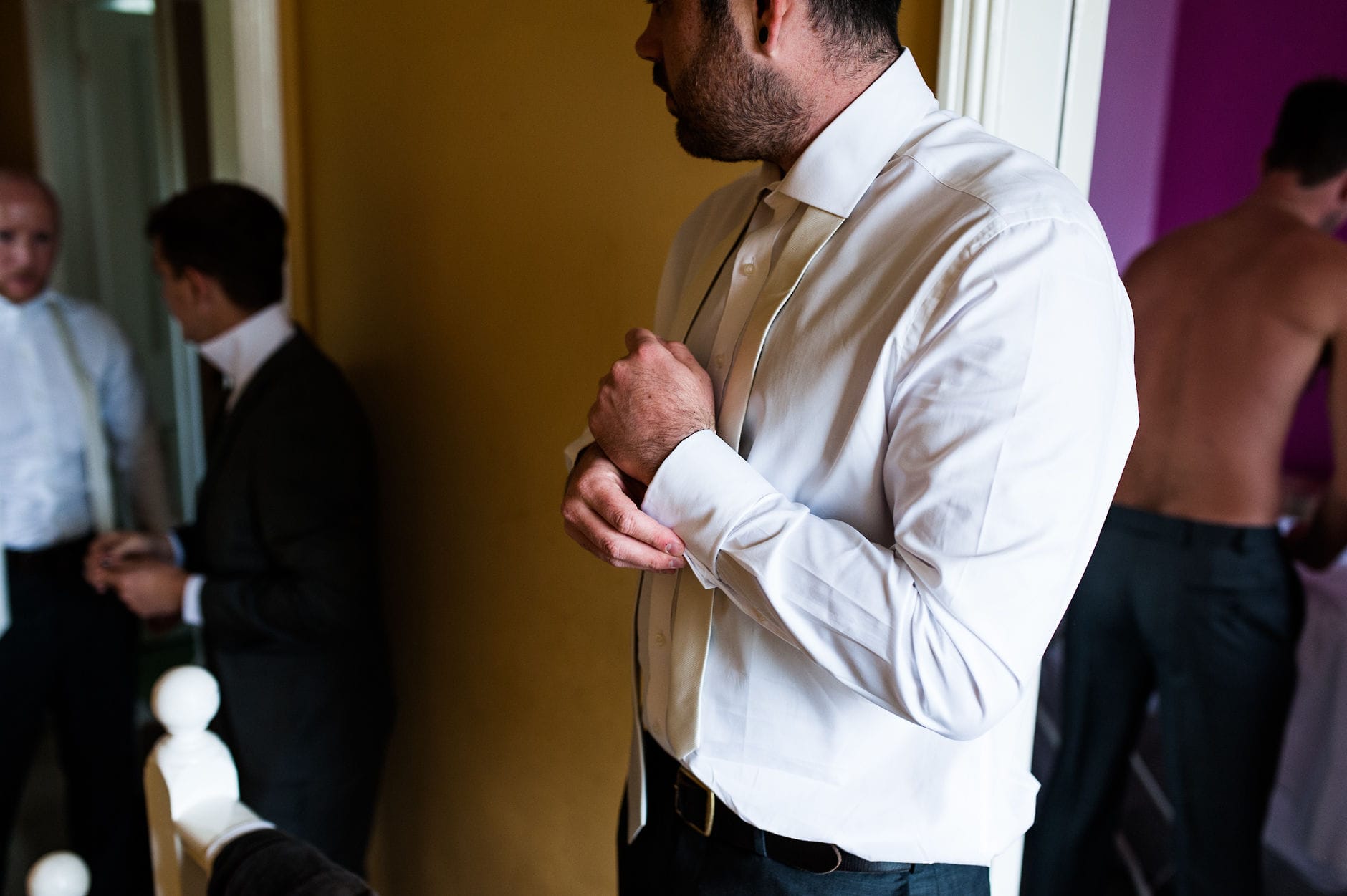 groom putting on cufflinks