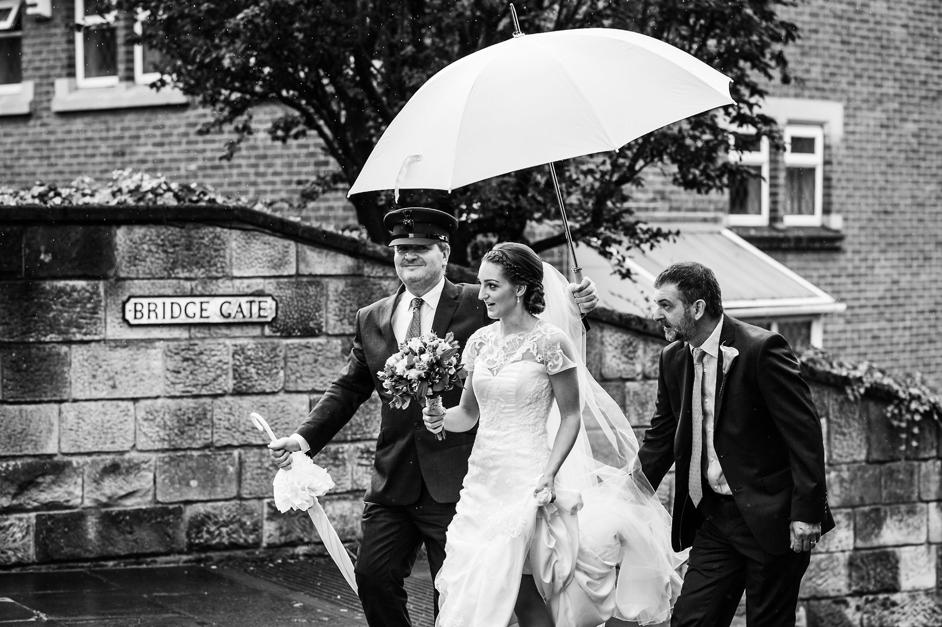 Bride arriving at church under huge umbrella