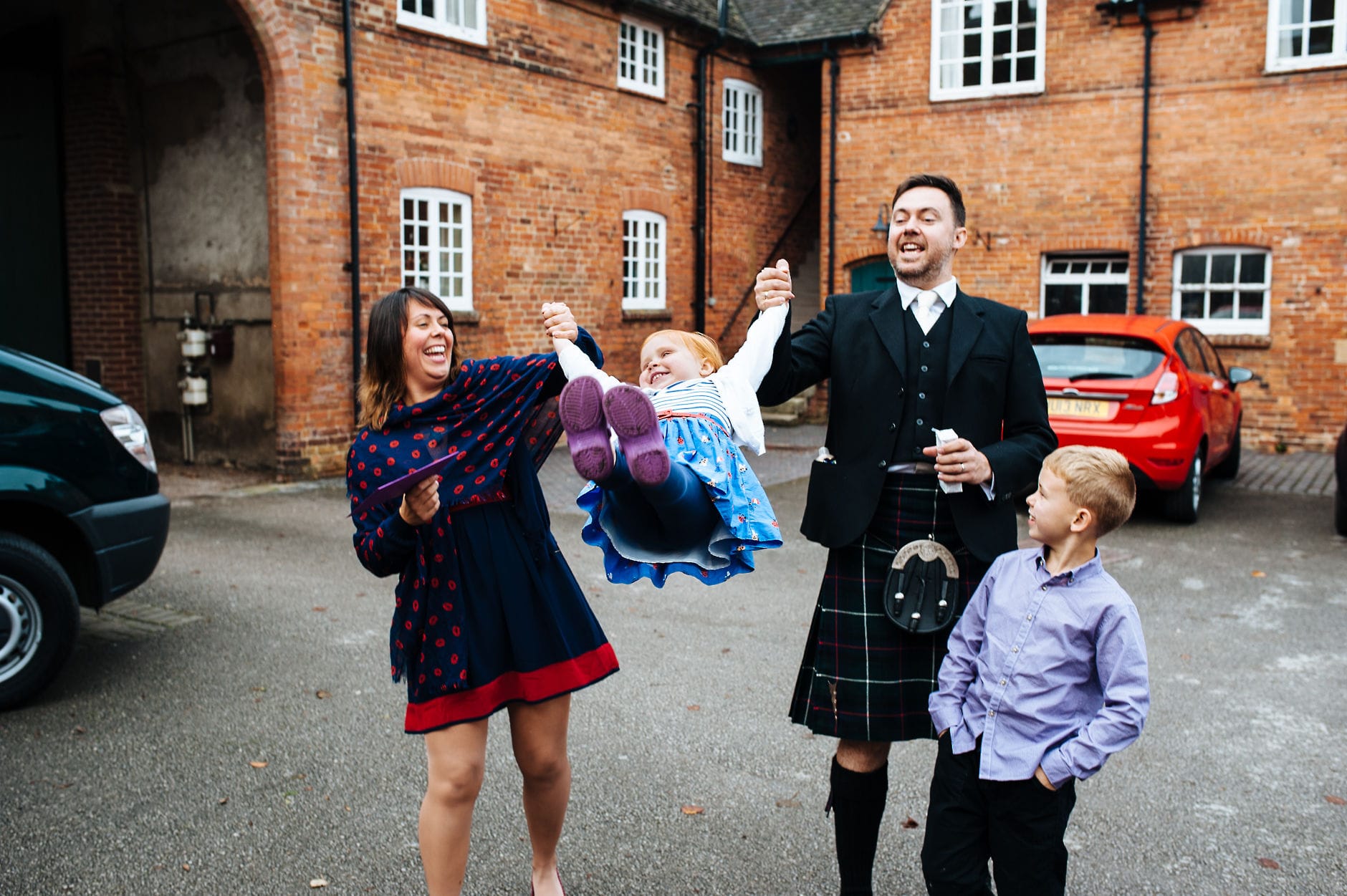 Parents swing their daughter