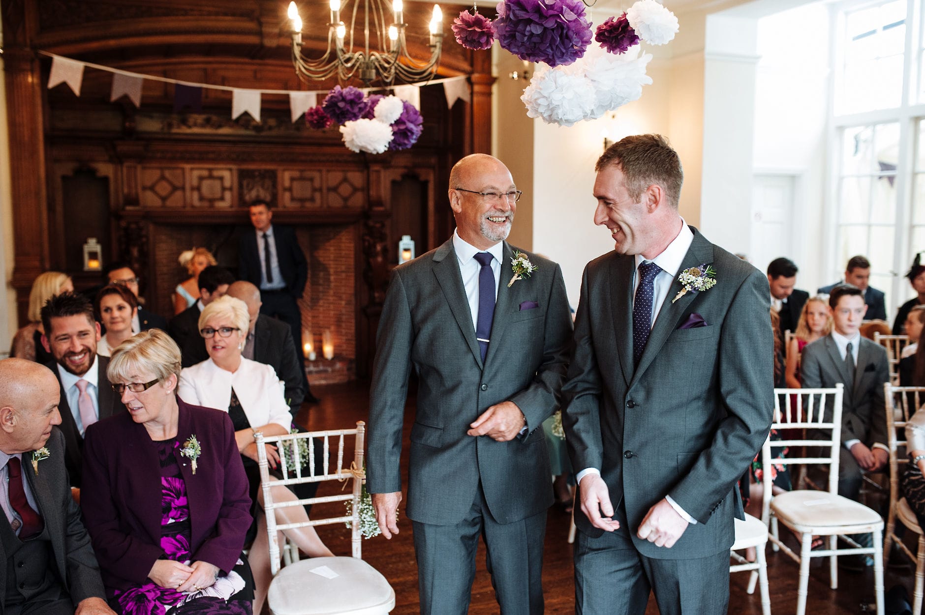 Groom and best man laughing in ceremony room