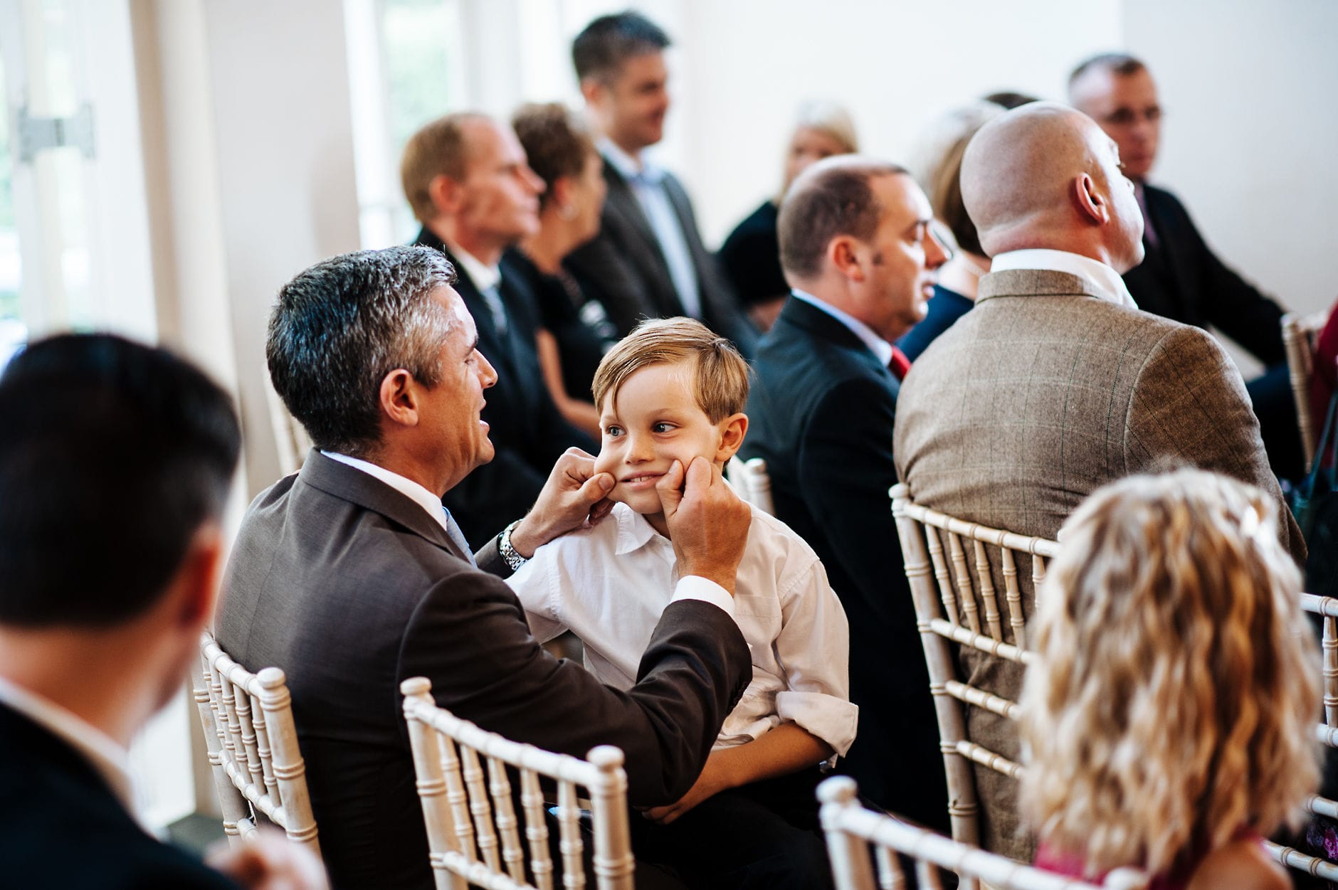funny photo of a dad pinching his son's cheeks