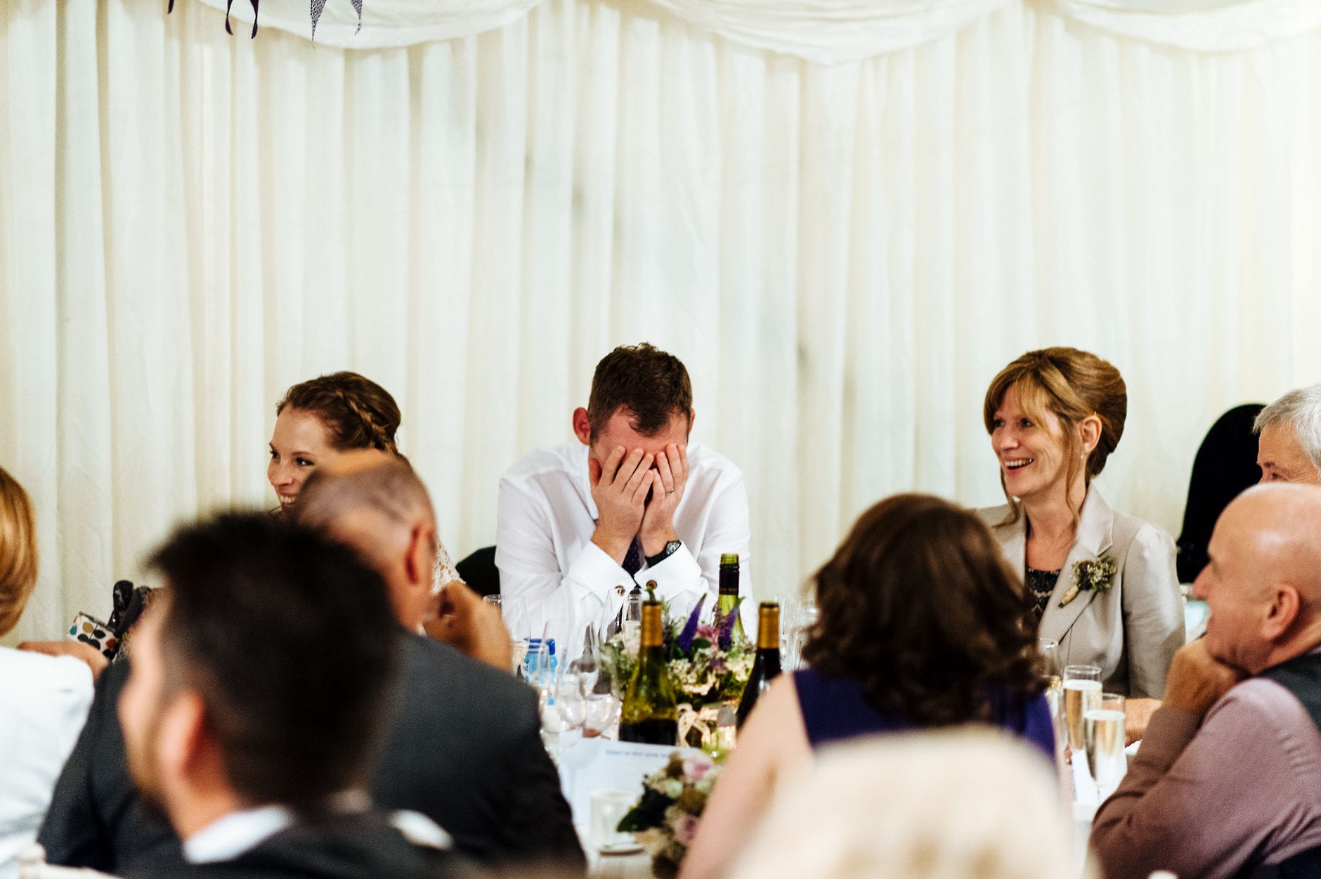 Groom has his head in hands during speeches
