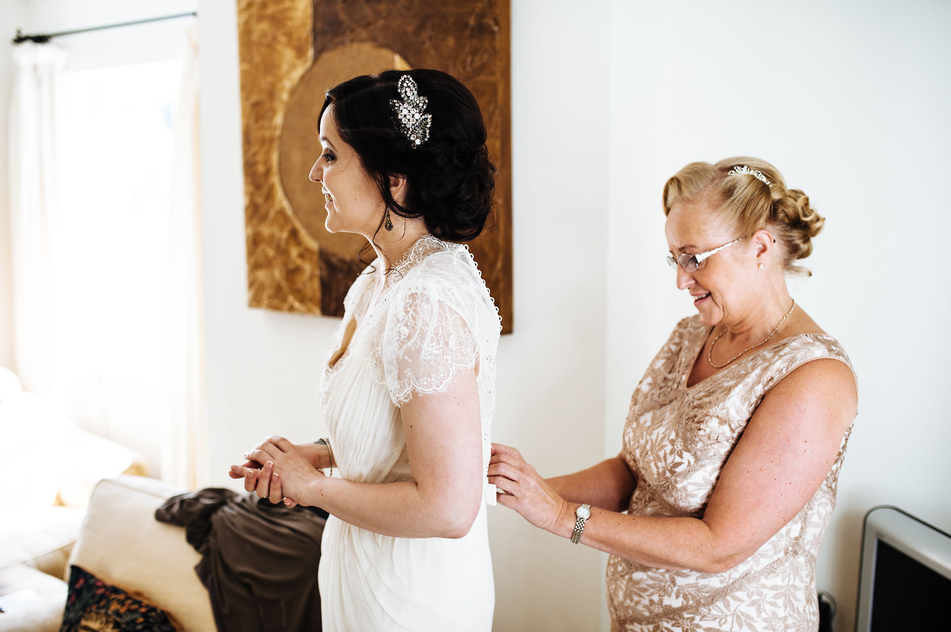 bride's mum helps her with her dress