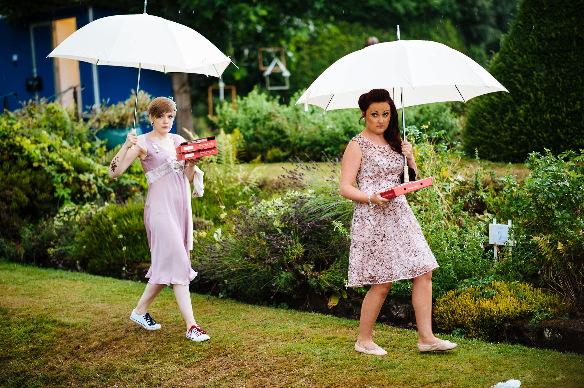 bridesmaids with umbrellas carrying supplies