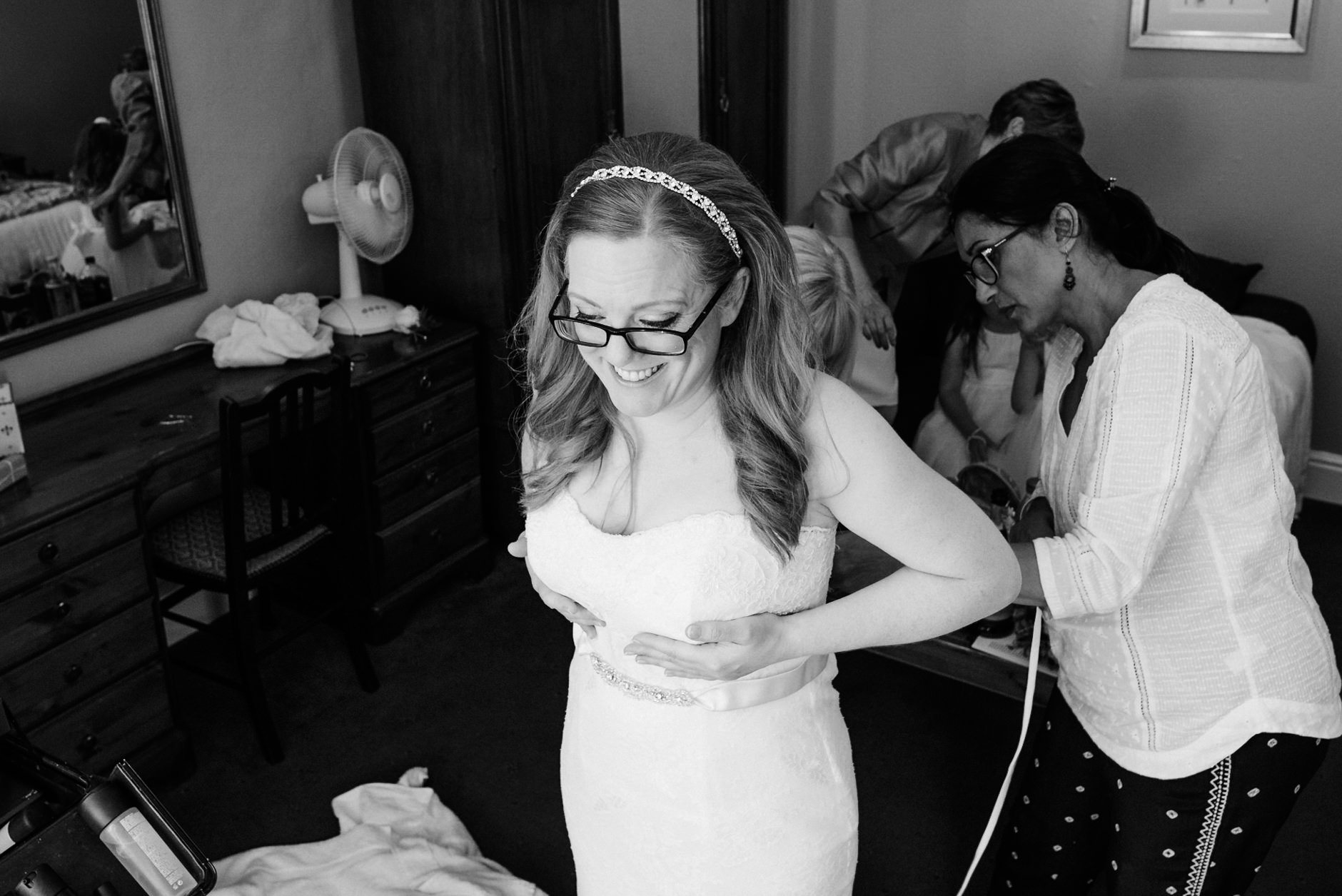 bride having her dress fastened