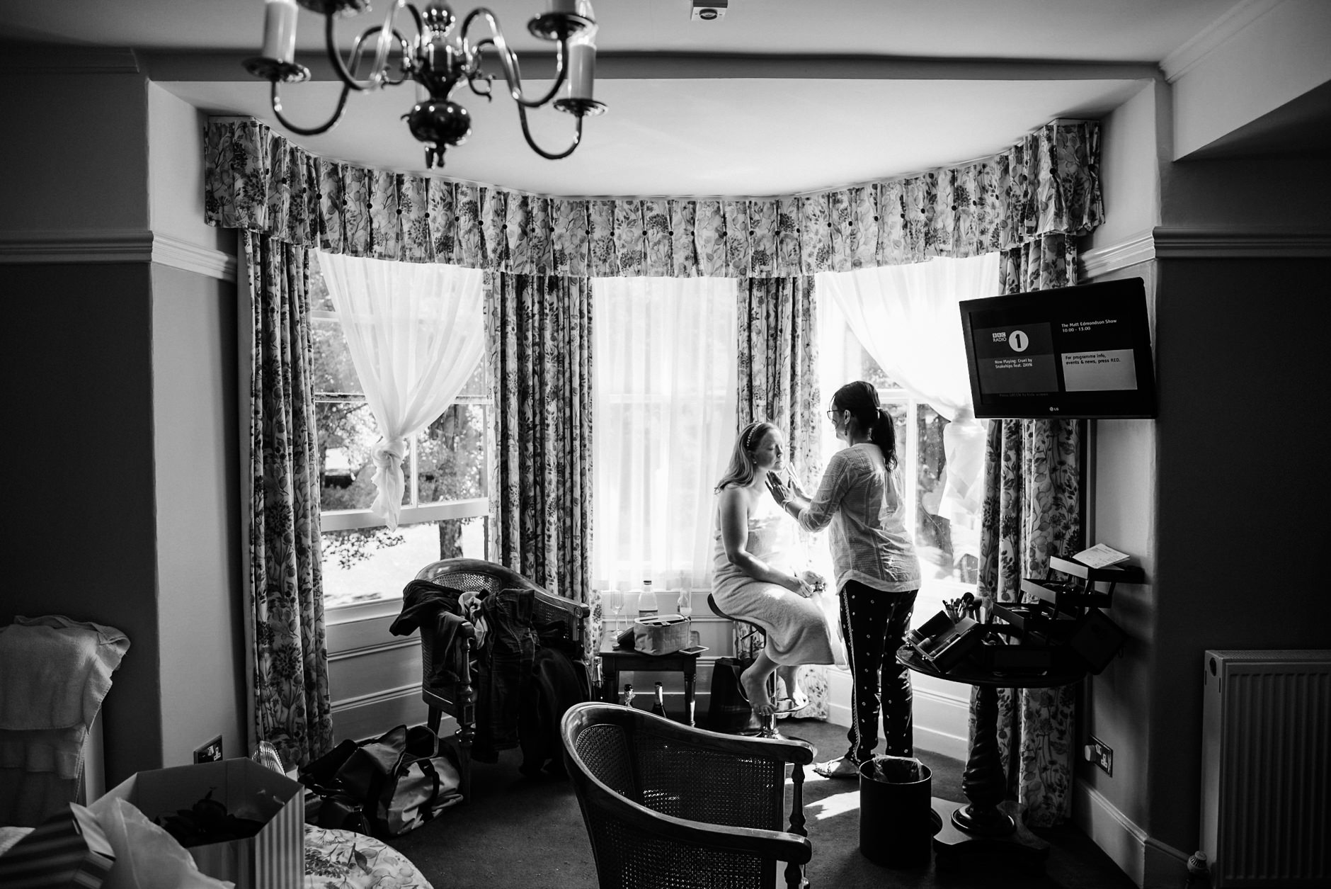 bride having her make up done in the hotel window