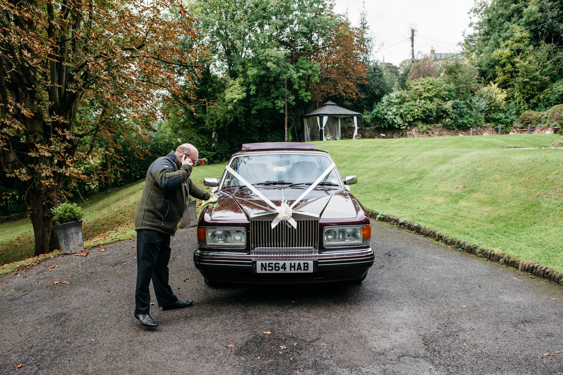 man on the phone polishing the wedding car
