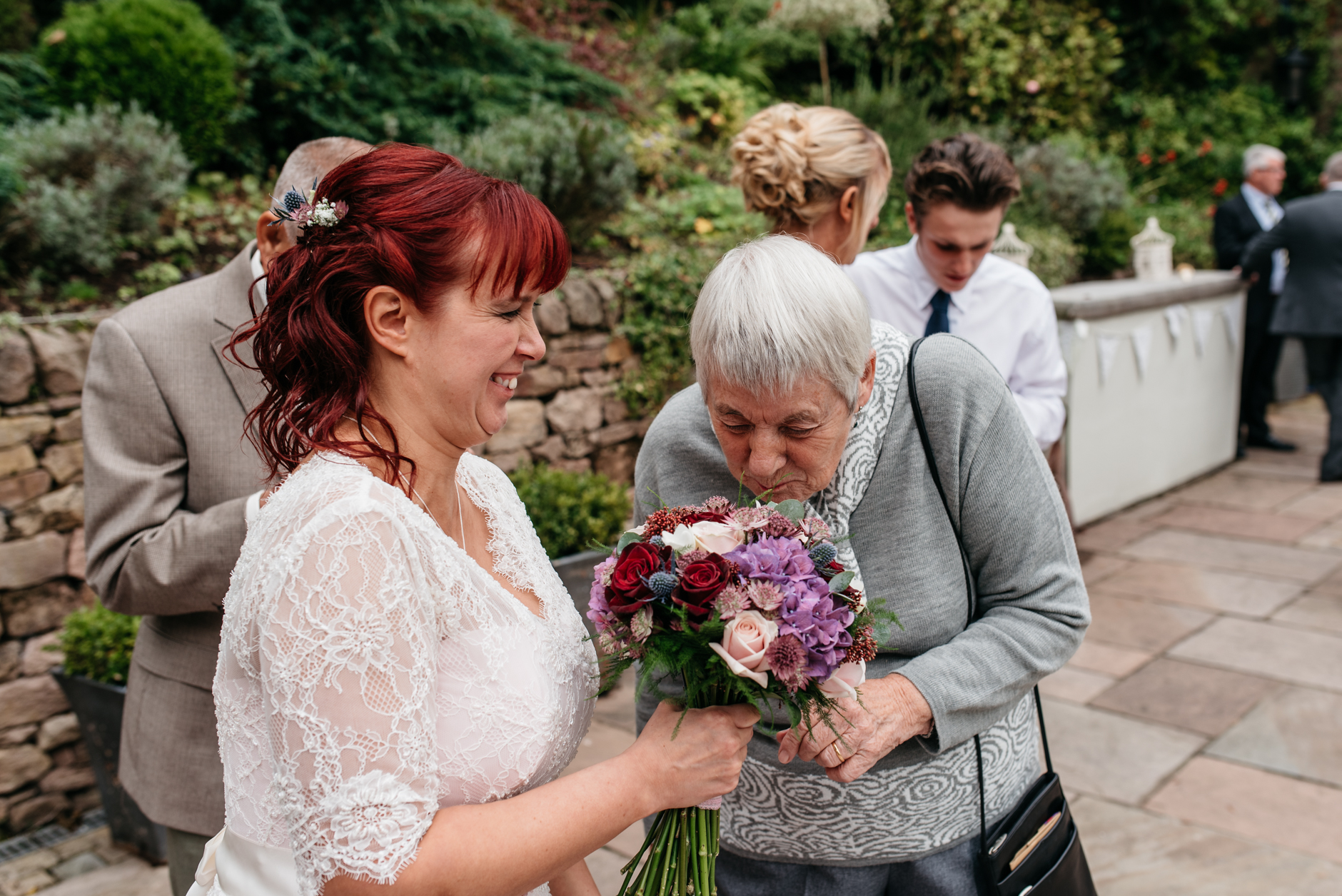 guest smelling the bride's bouquet