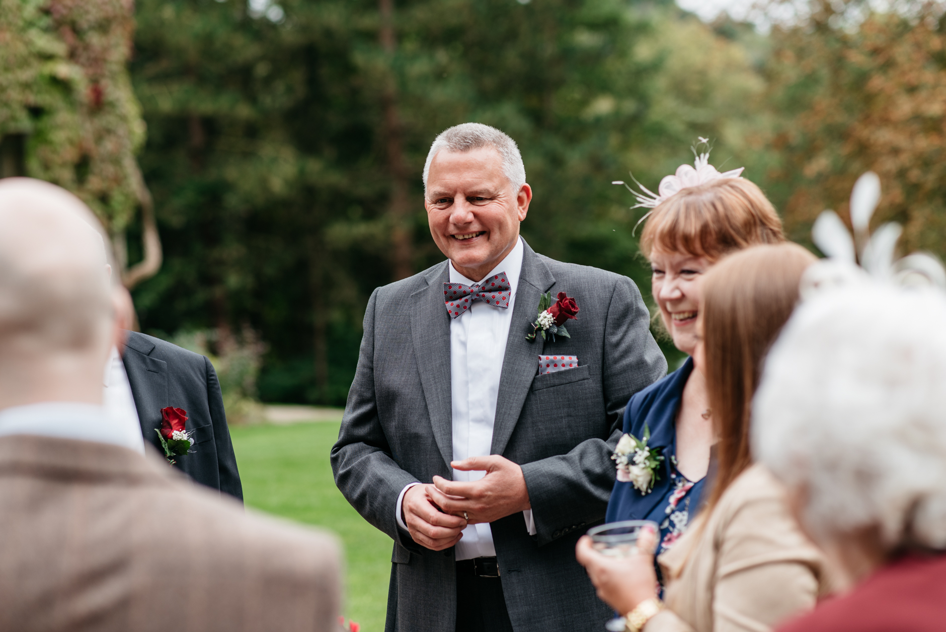 happy groom stood outside with friends