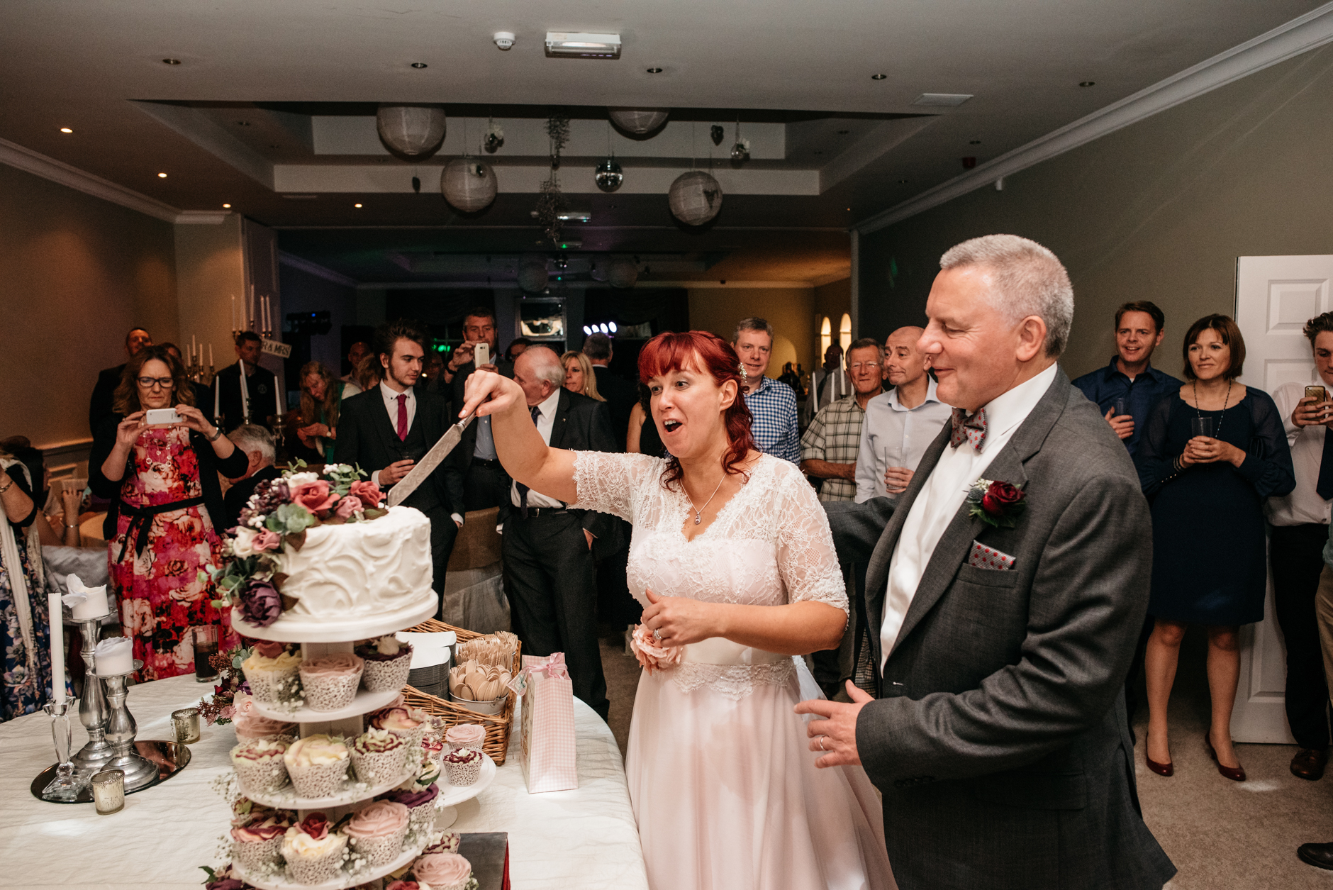 bride and groom having fun cutting the cake
