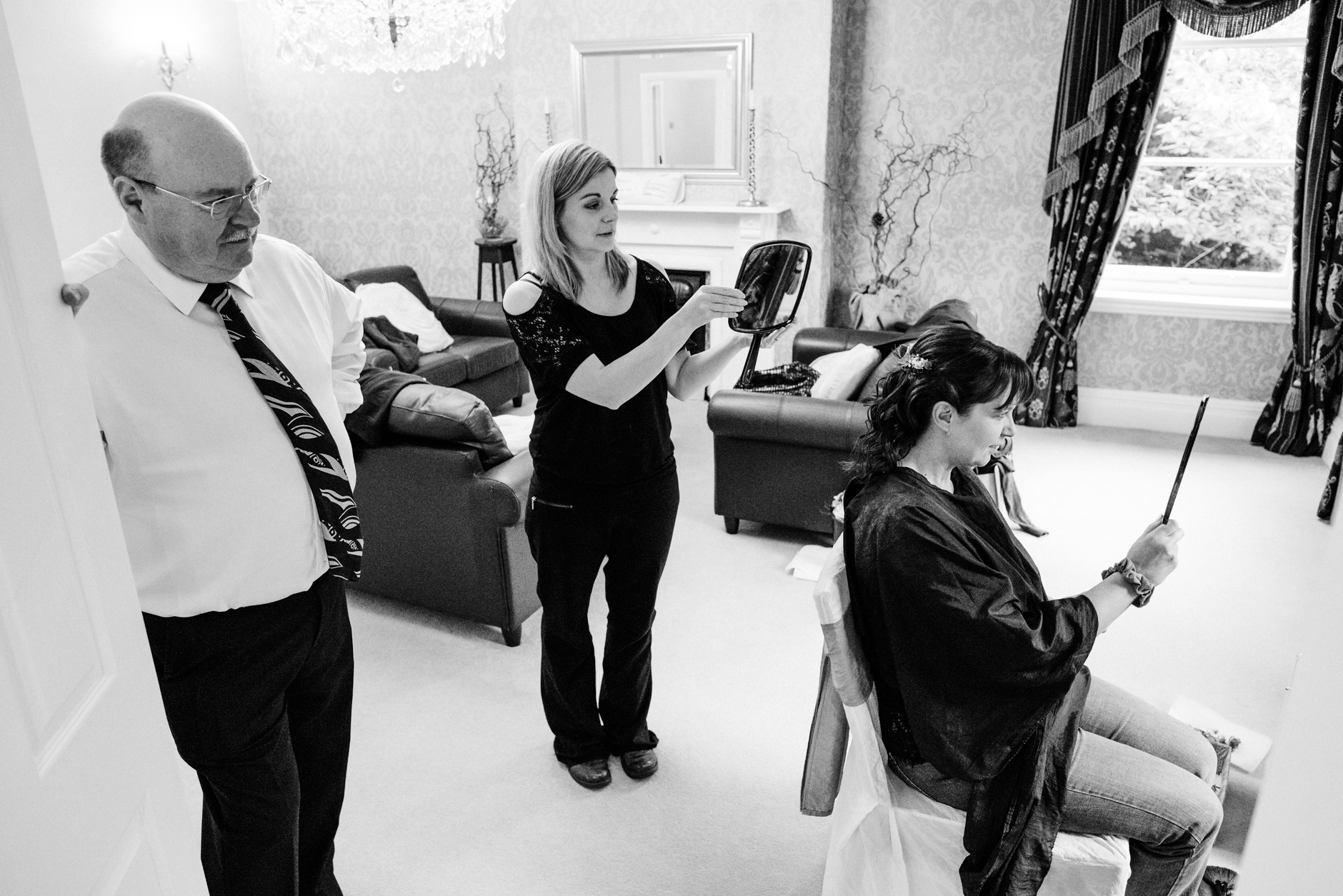 hairdresser holding up a mirror for bride