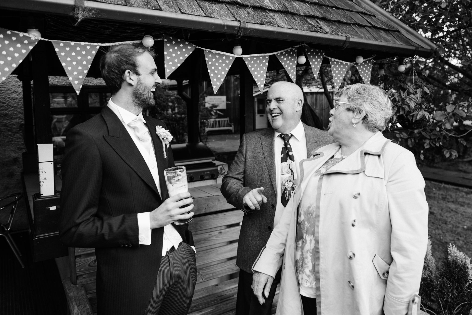 Groom laughing with guests at the pub