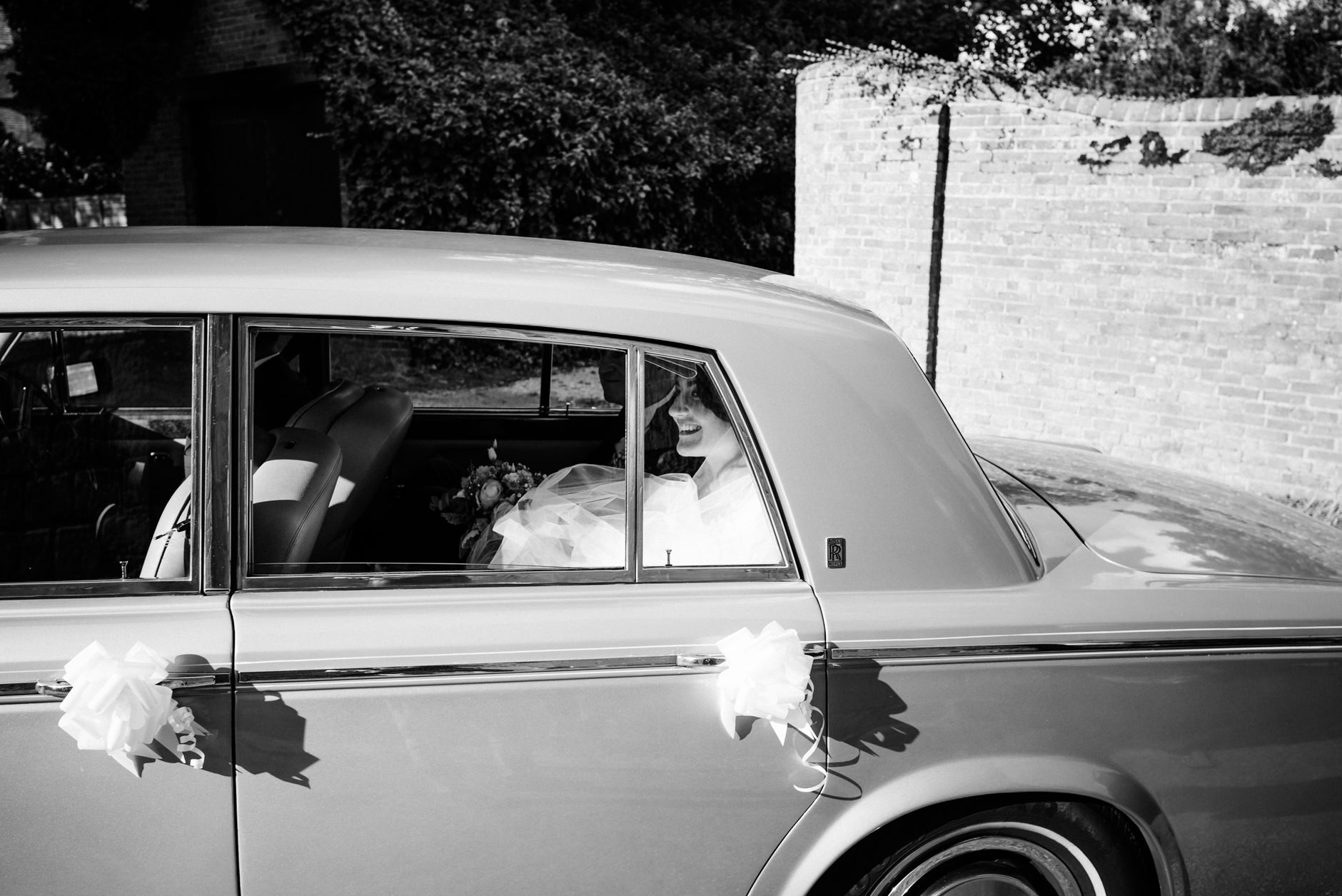 Bride smiling through the car window