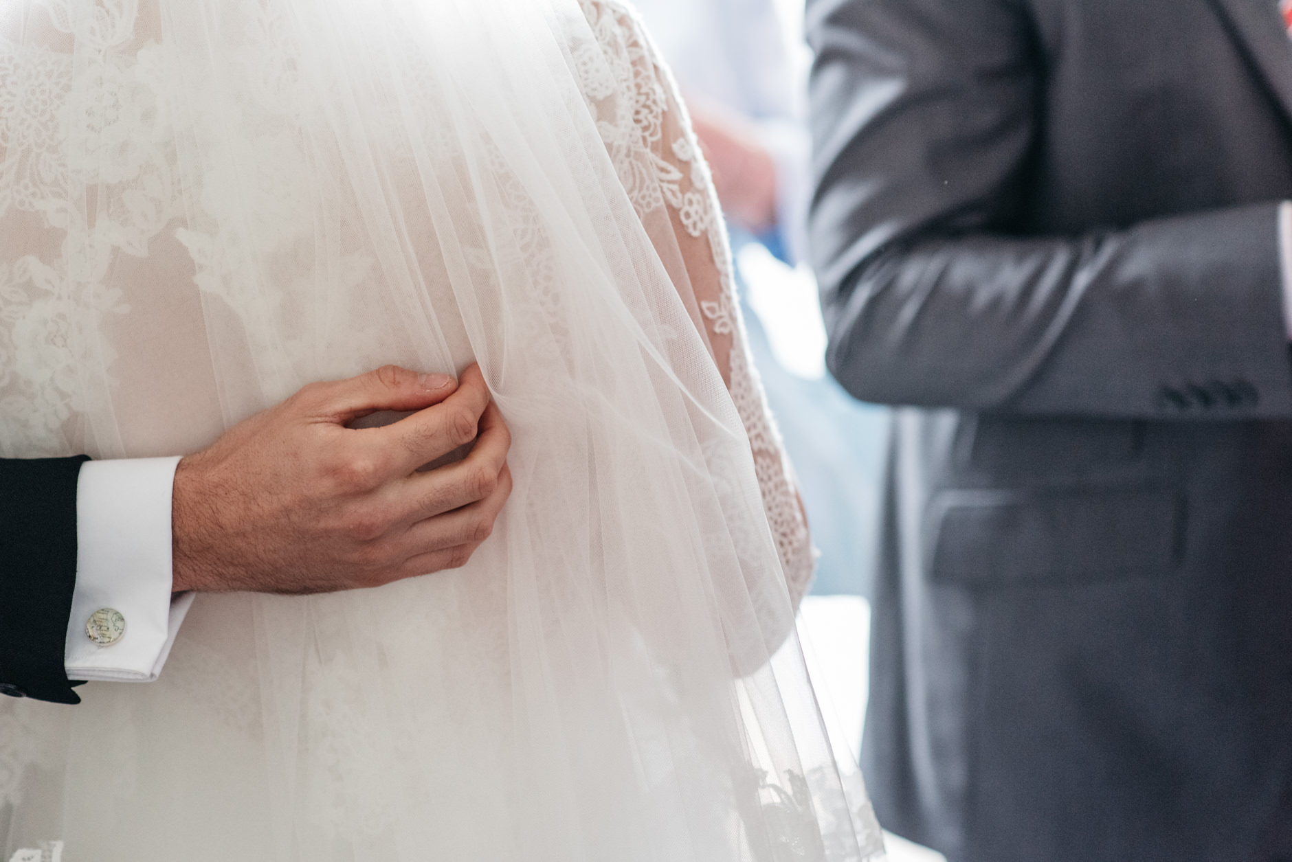 Groom's hand on his wife's dress