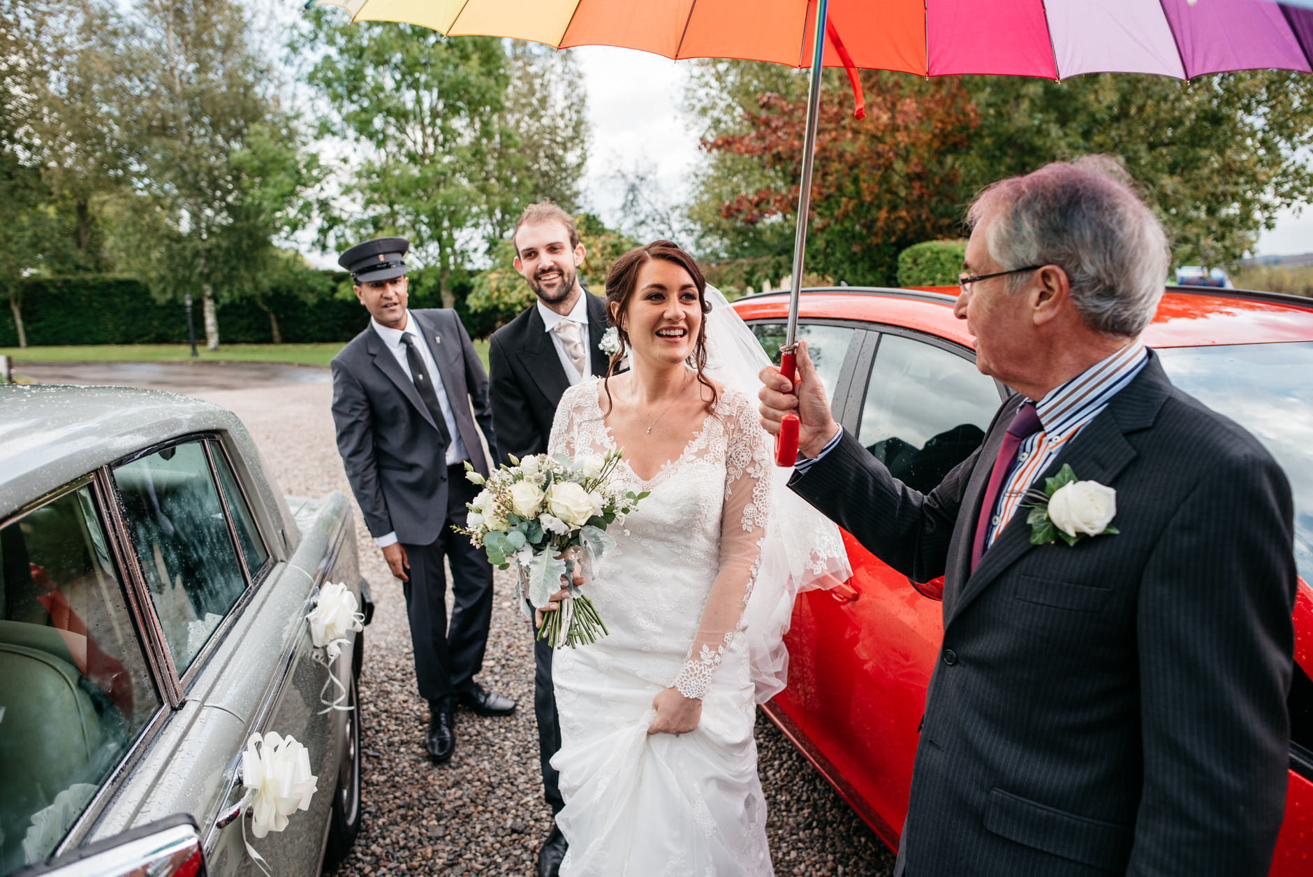 Bride and groom arrive at reception under umbrella