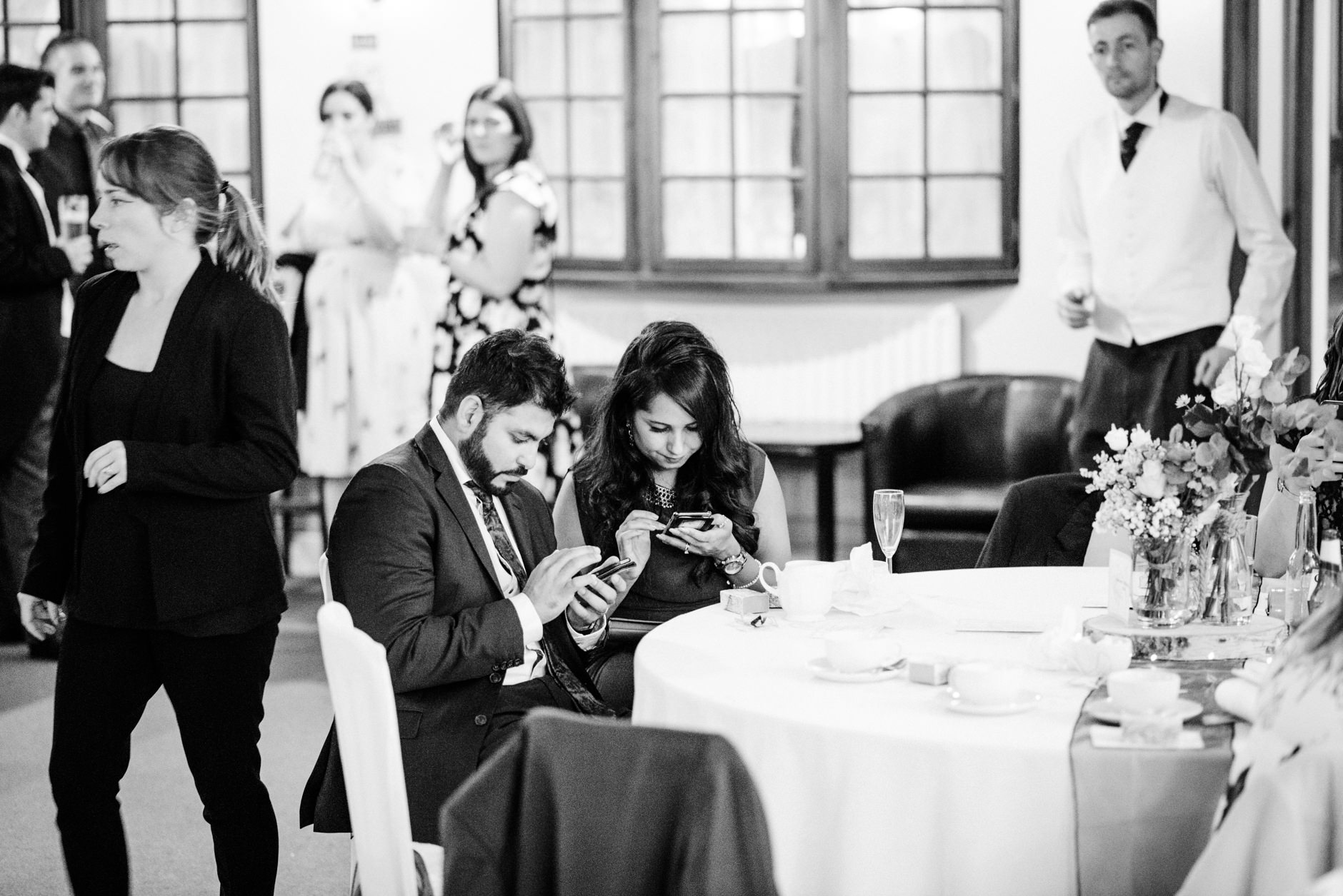 A couple of wedding guests checking their phones