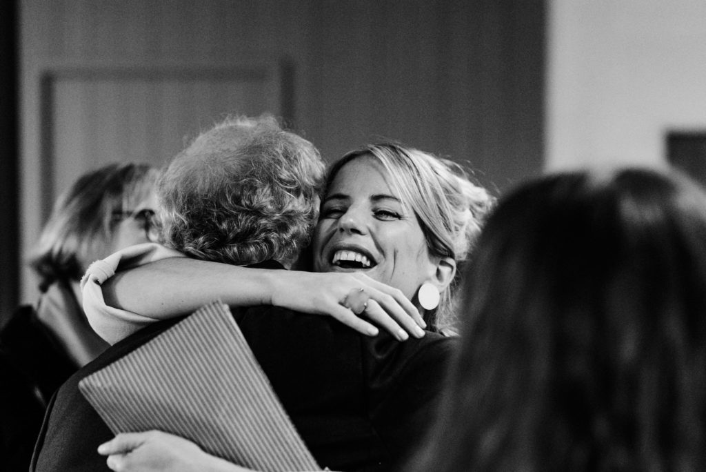 groom's sister greeting guests with a hug