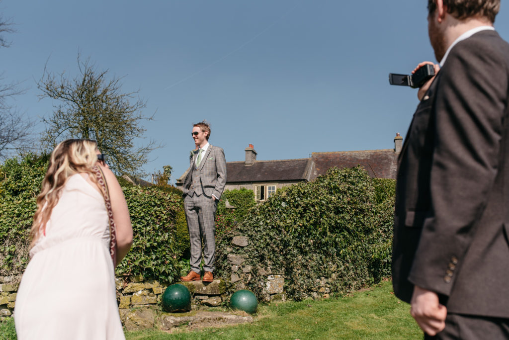 groom posing for guest photos