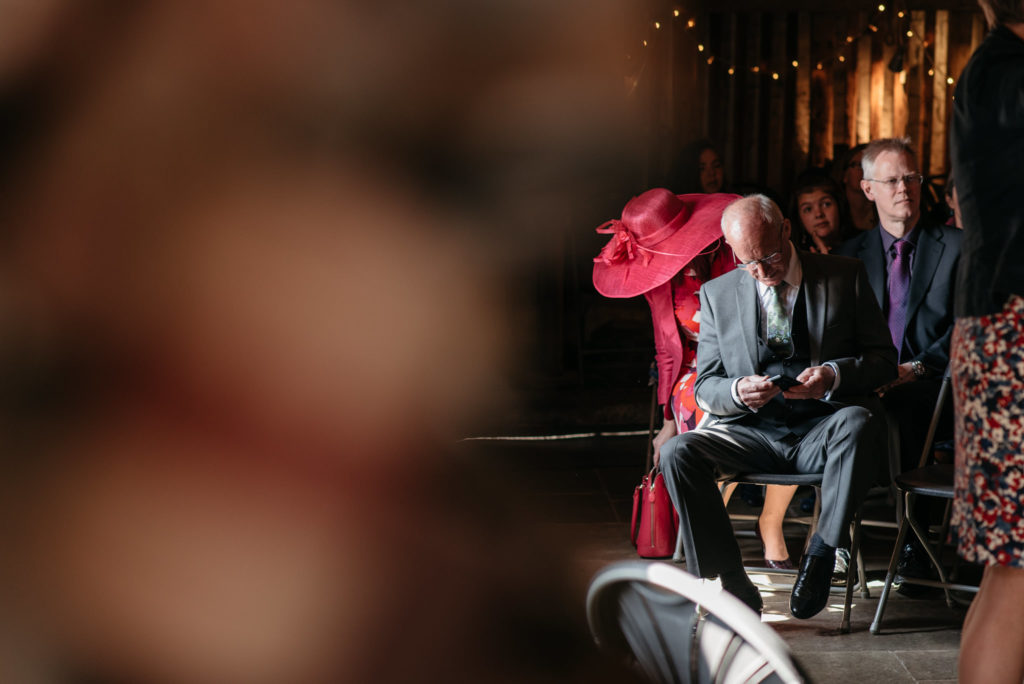 wedding guest checking his phone