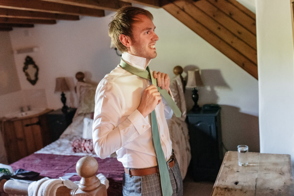 groom putting on his tie