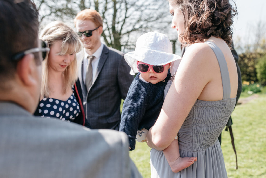 baby wedding guest in sun hat and sunglasses