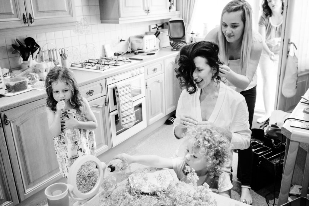 bride getting hair done in kitchen