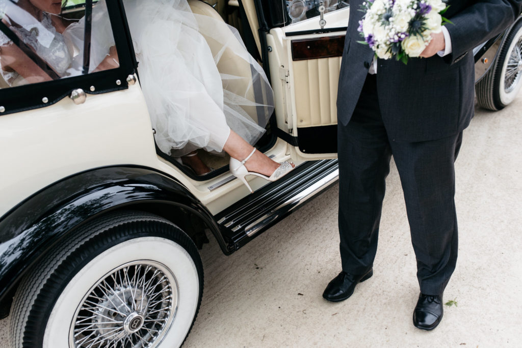bride stepping out of wedding car