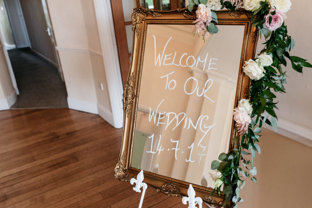 welcome to wedding sign written on mirror