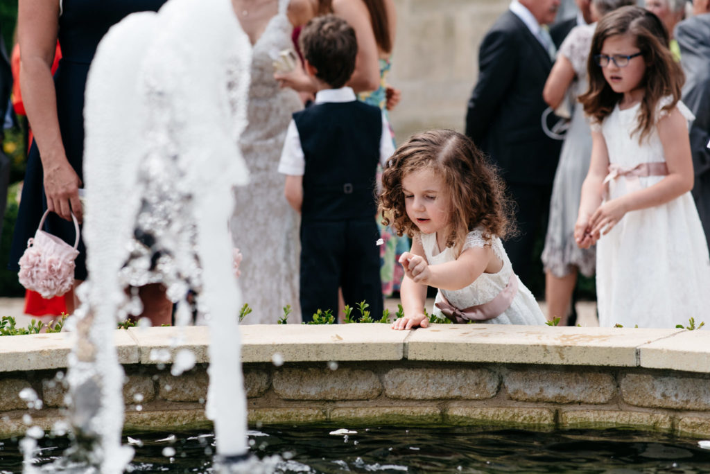 little girl throwing stones into the fountain