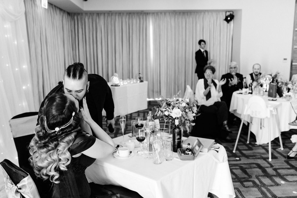 newlyweds share a kiss after speeches