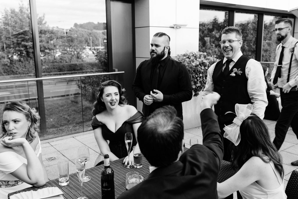 bride and groom share a joke with friends
