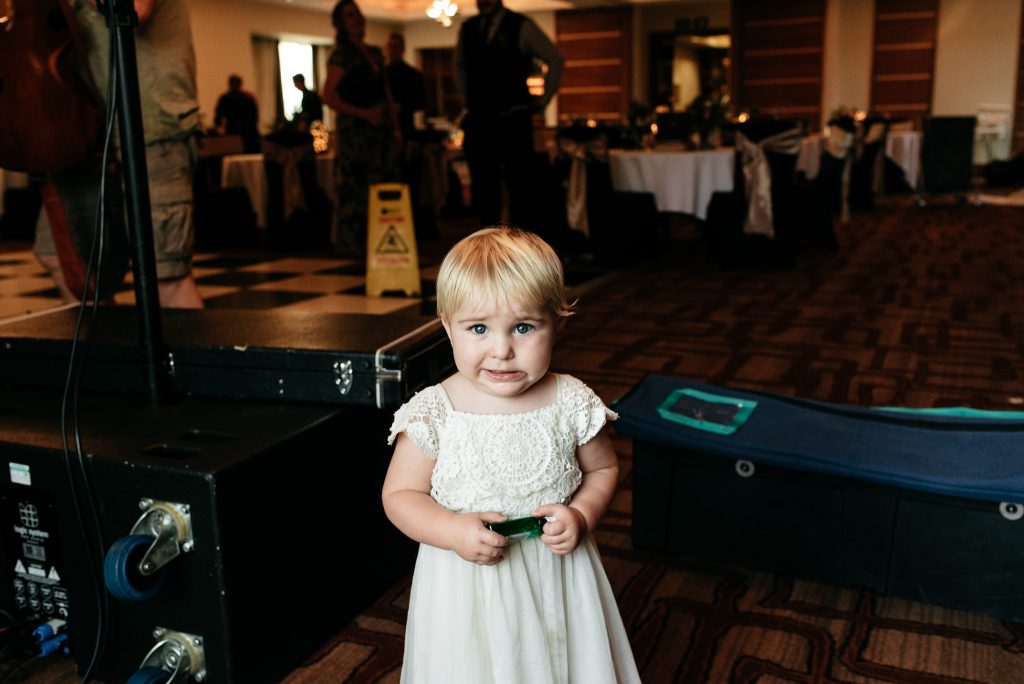 little girl holding a miniature gin bottle