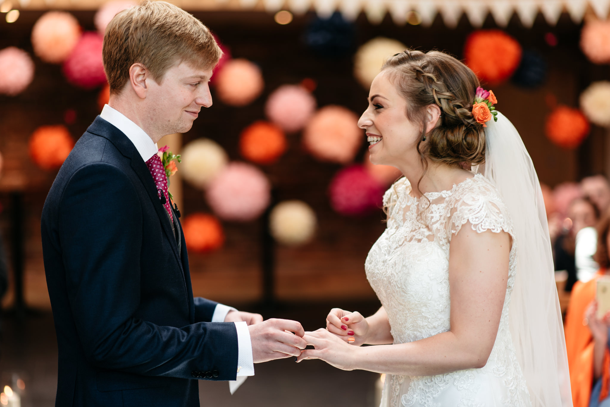 bride and groom exchanging rings at mythe barn leicestershire wedding 