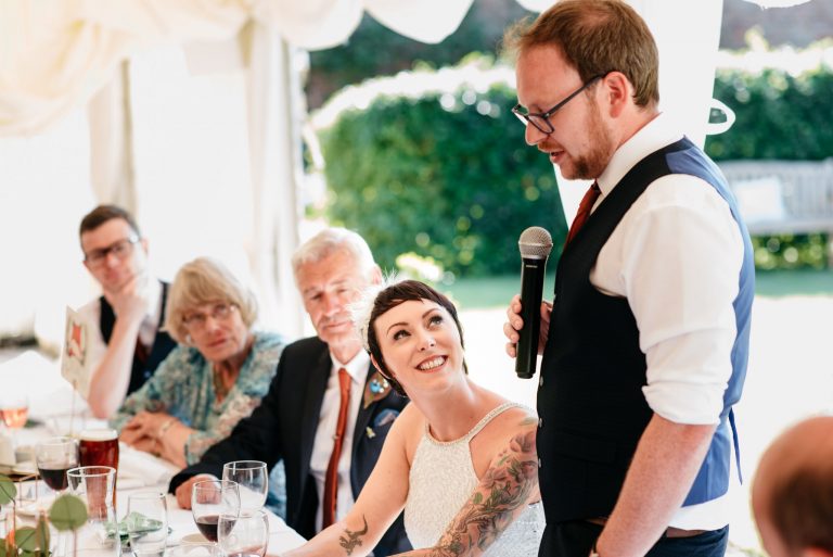 bride looking at her new husband during his speech