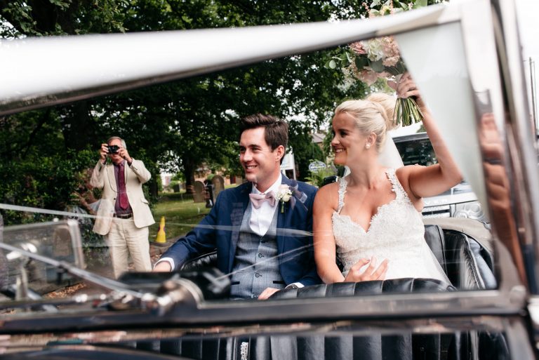 just married in open top wedding car