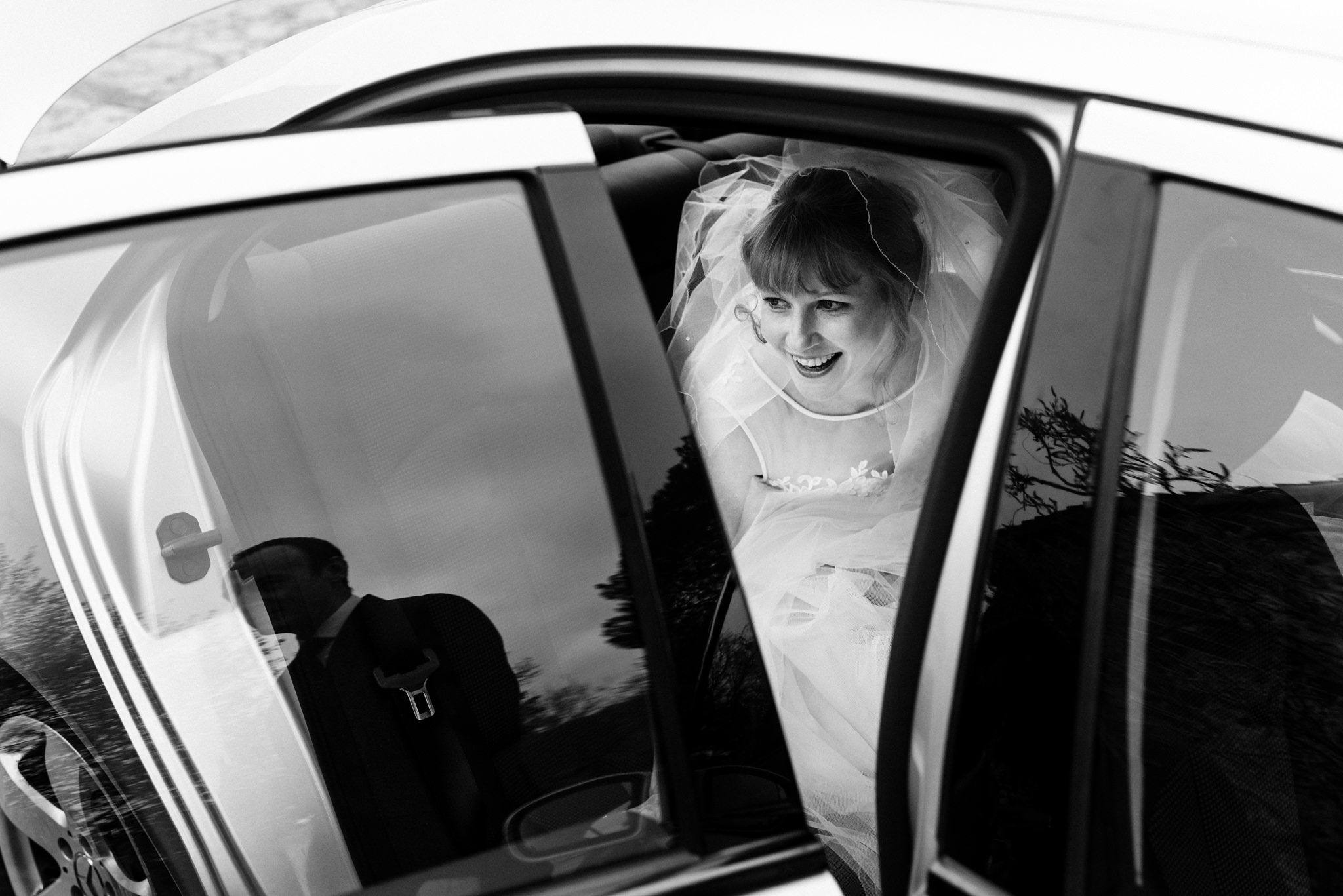 smiling bride getting out of wedding car