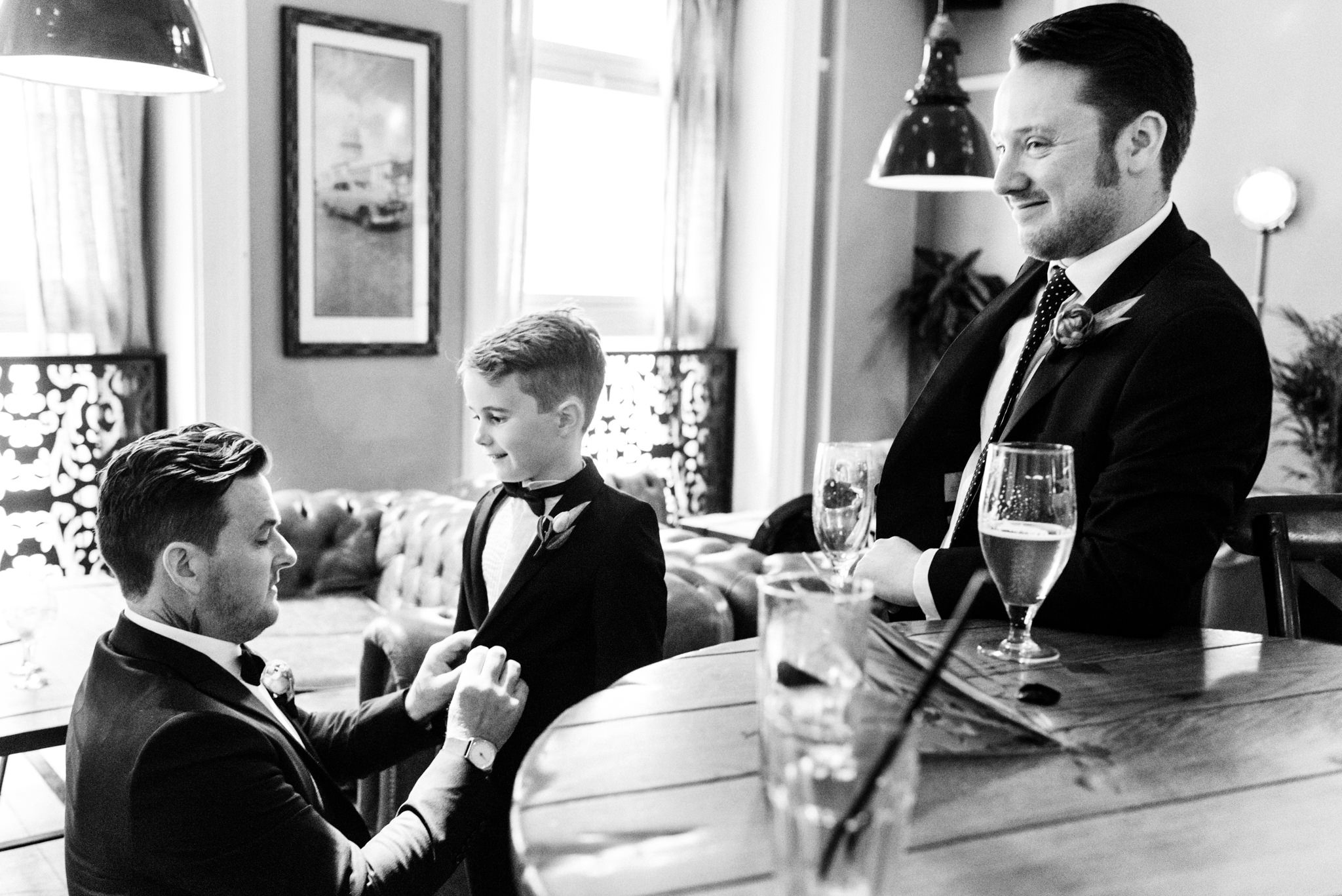 groom helping his son with tuxedo