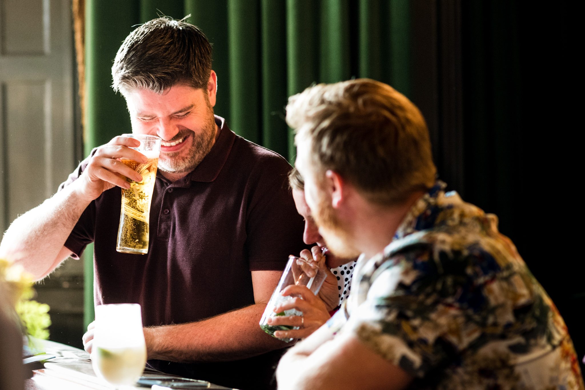 friends share a joke over a drink