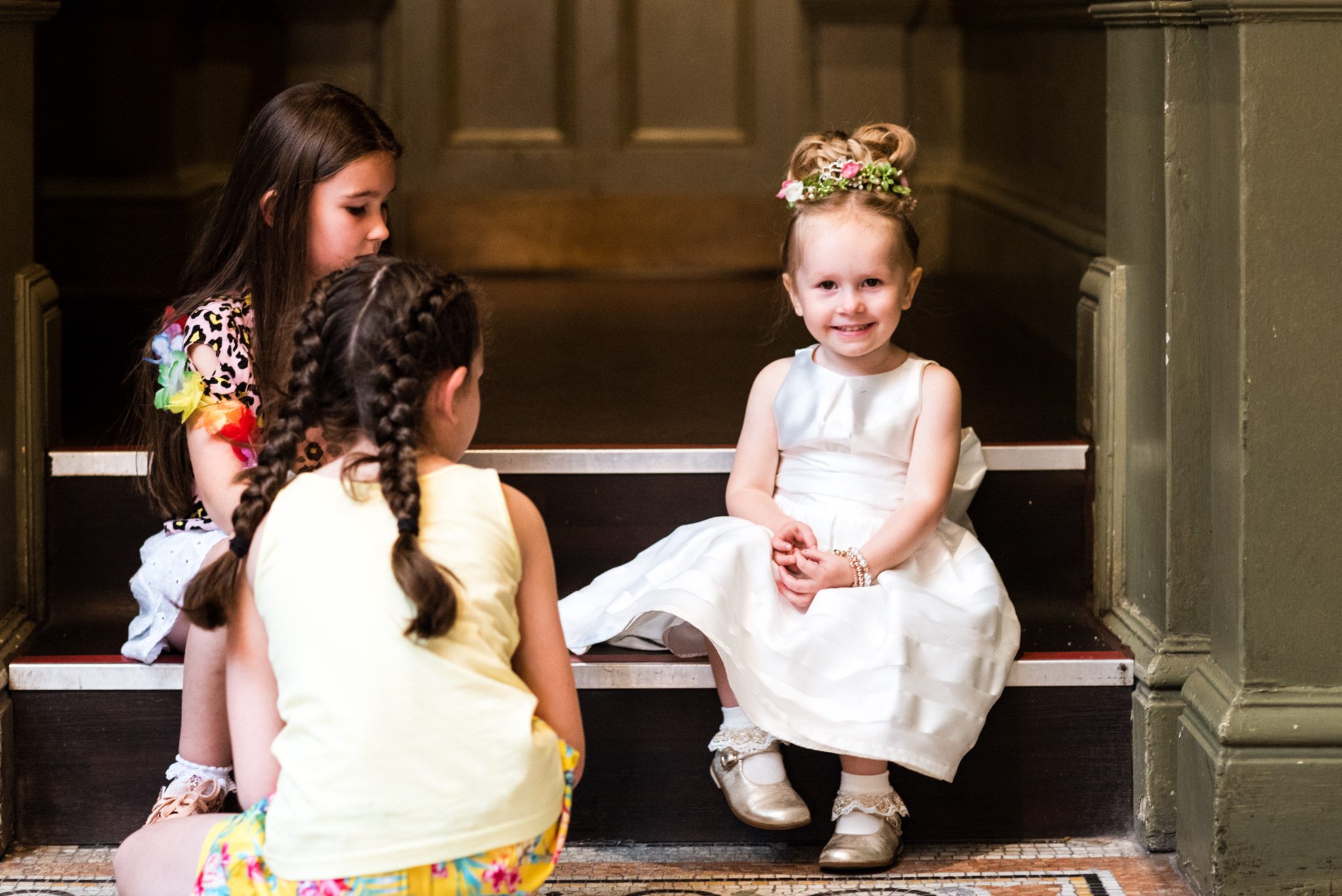 cute little flower girl sat on a step