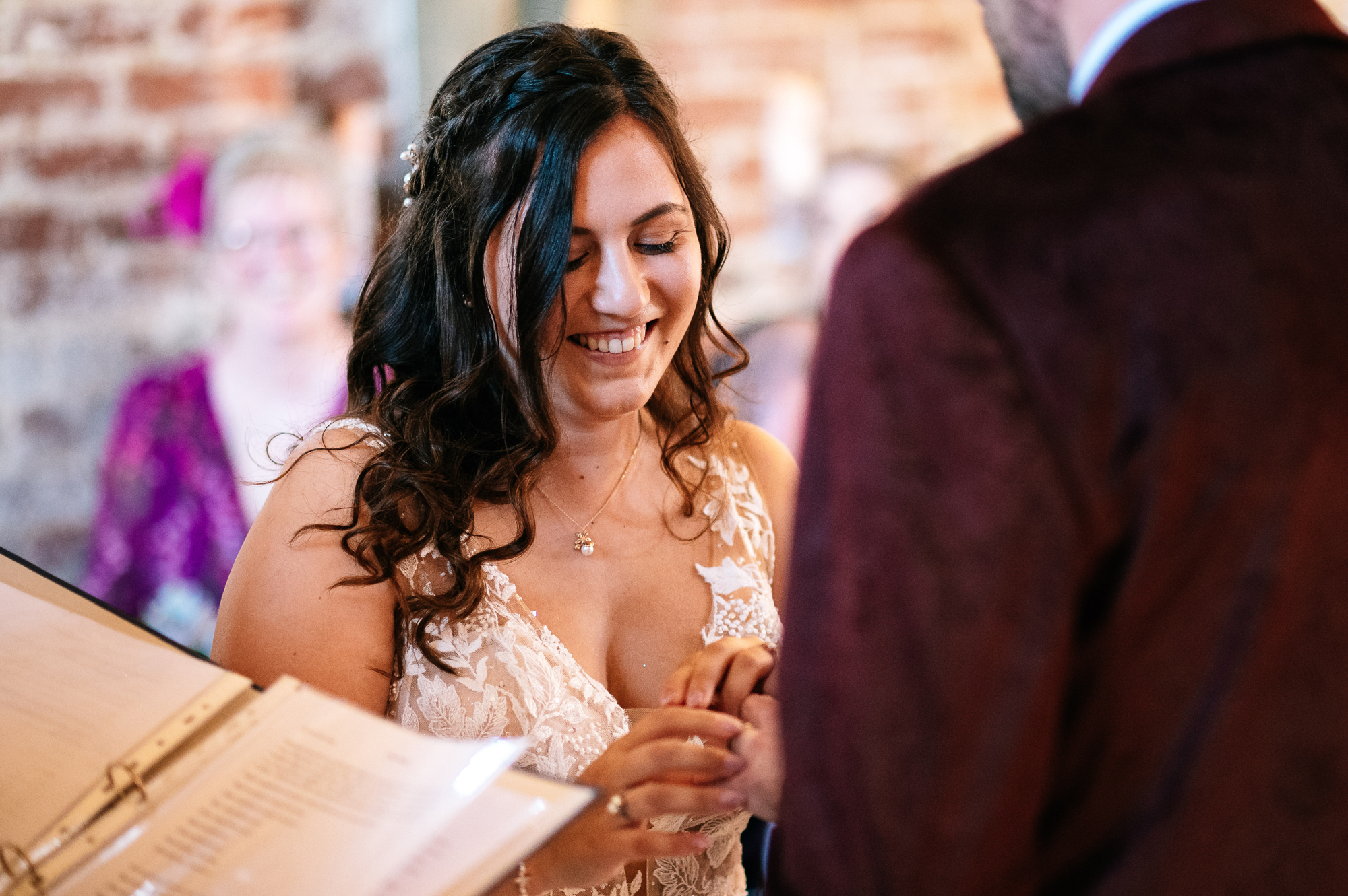happy bride during ring exchange at barn wedding