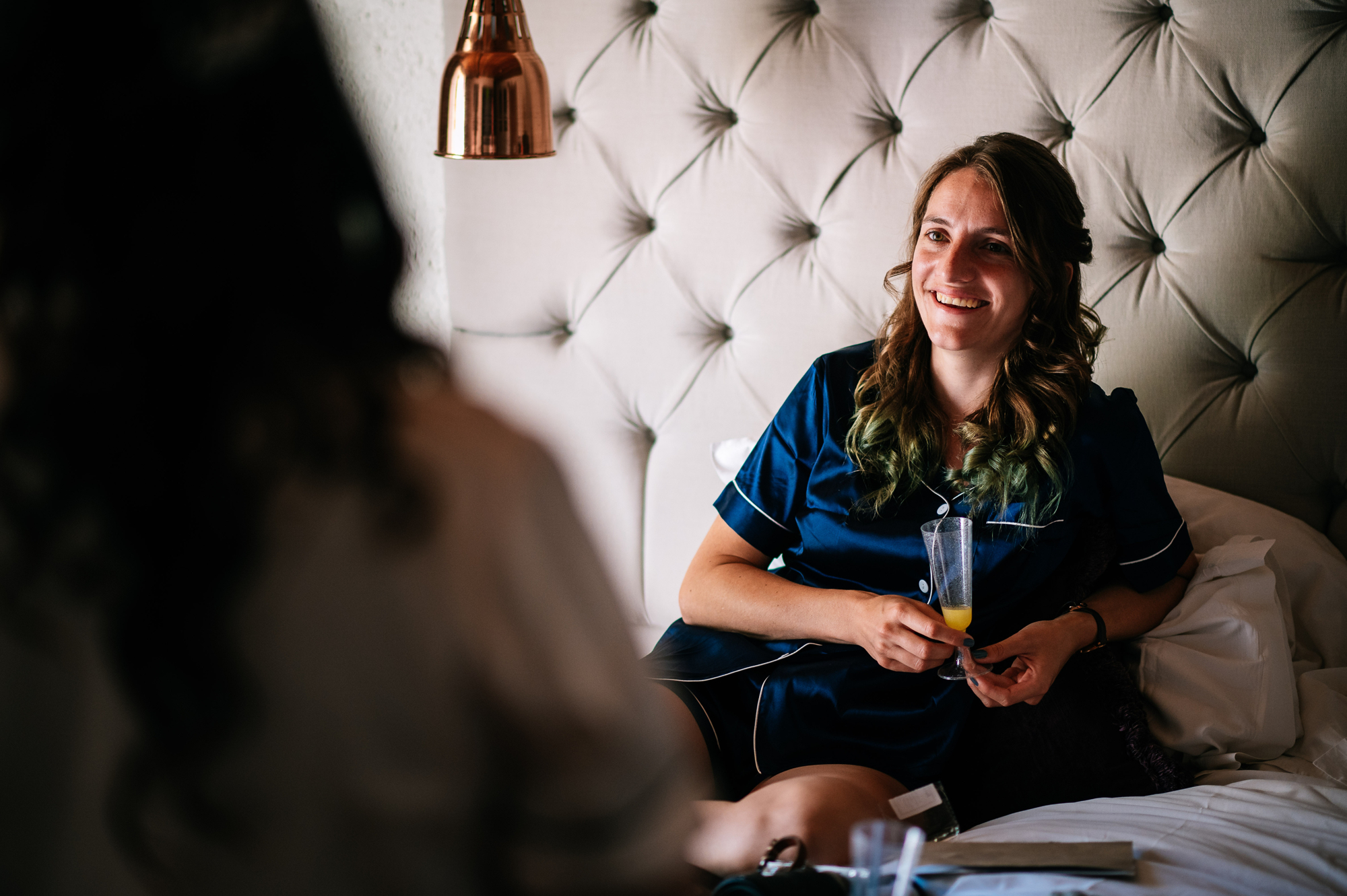 smiling bridesmaid sitting on the bed