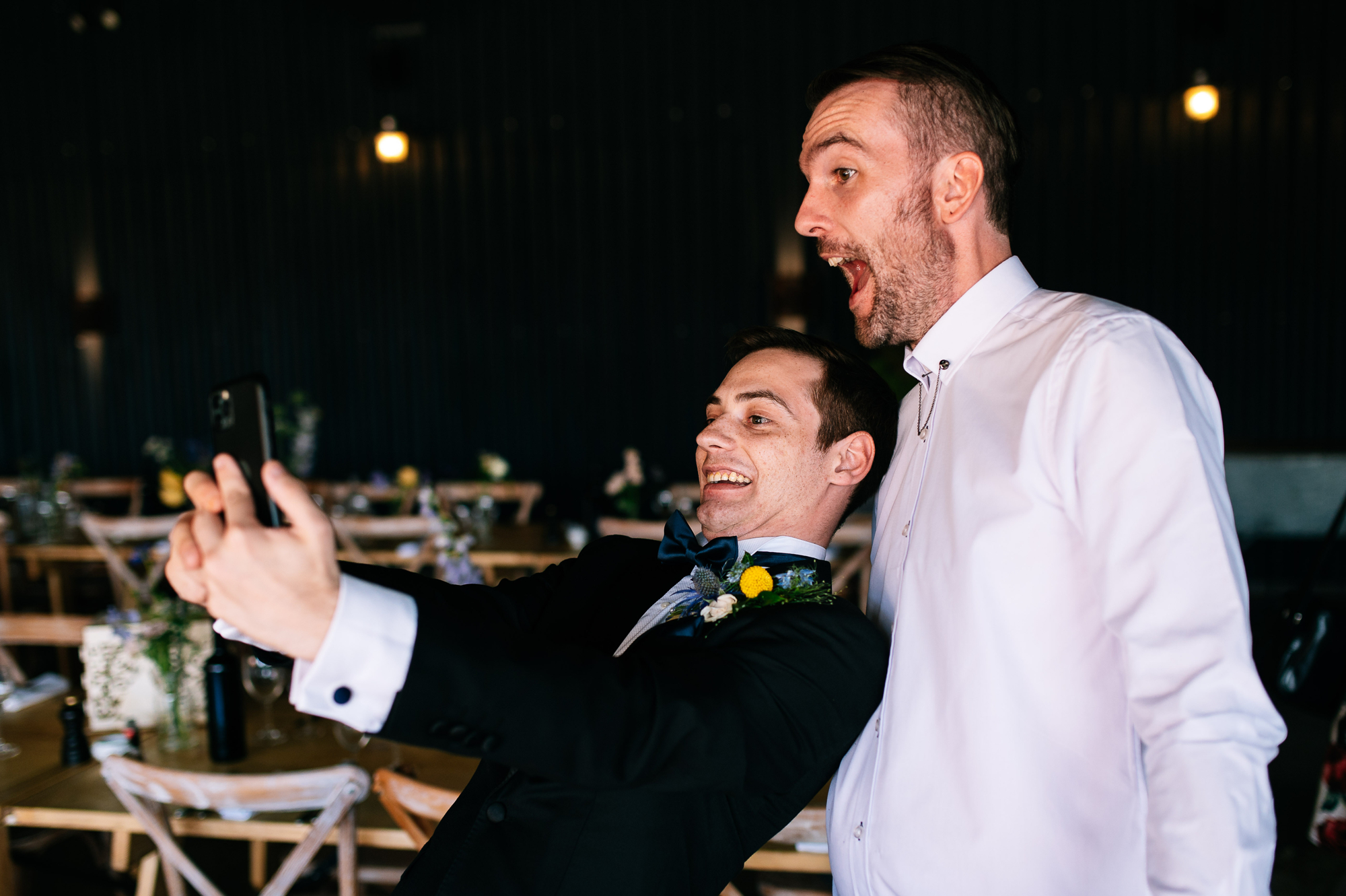bride's brother taking a selfie with the groom