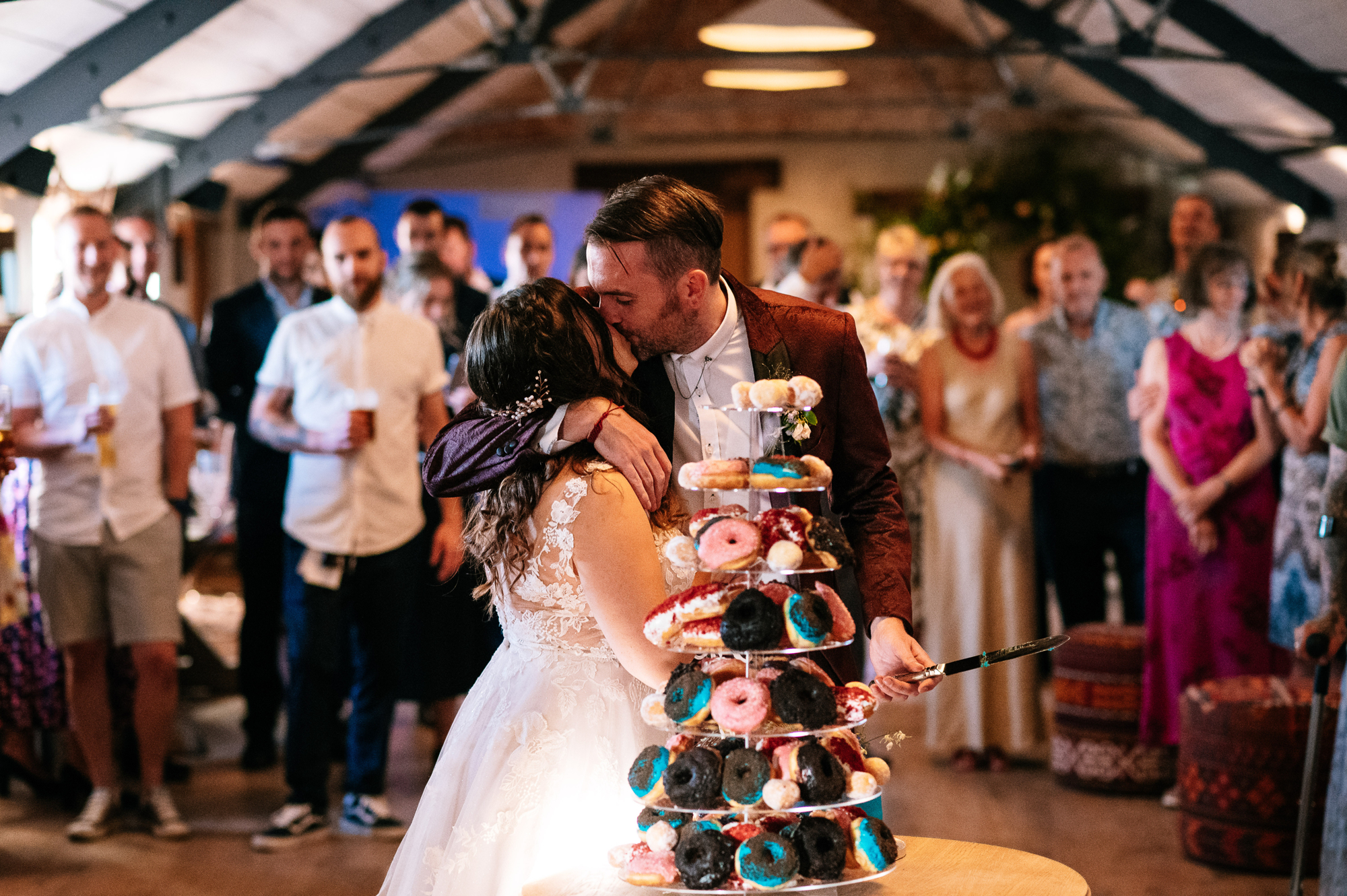 bride and groom kissing before cutting their cake